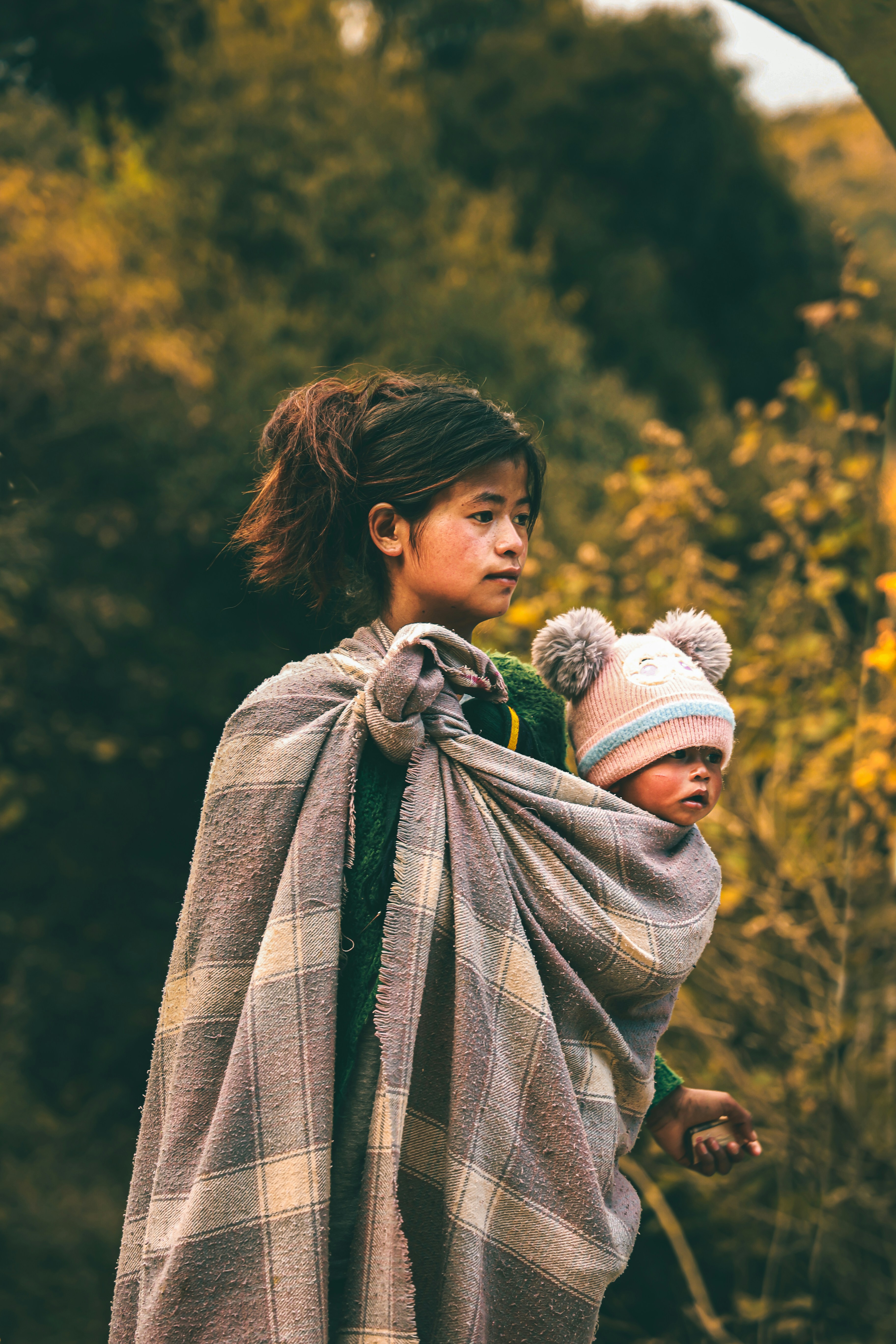 Young Mother Carrying Baby Outdoors