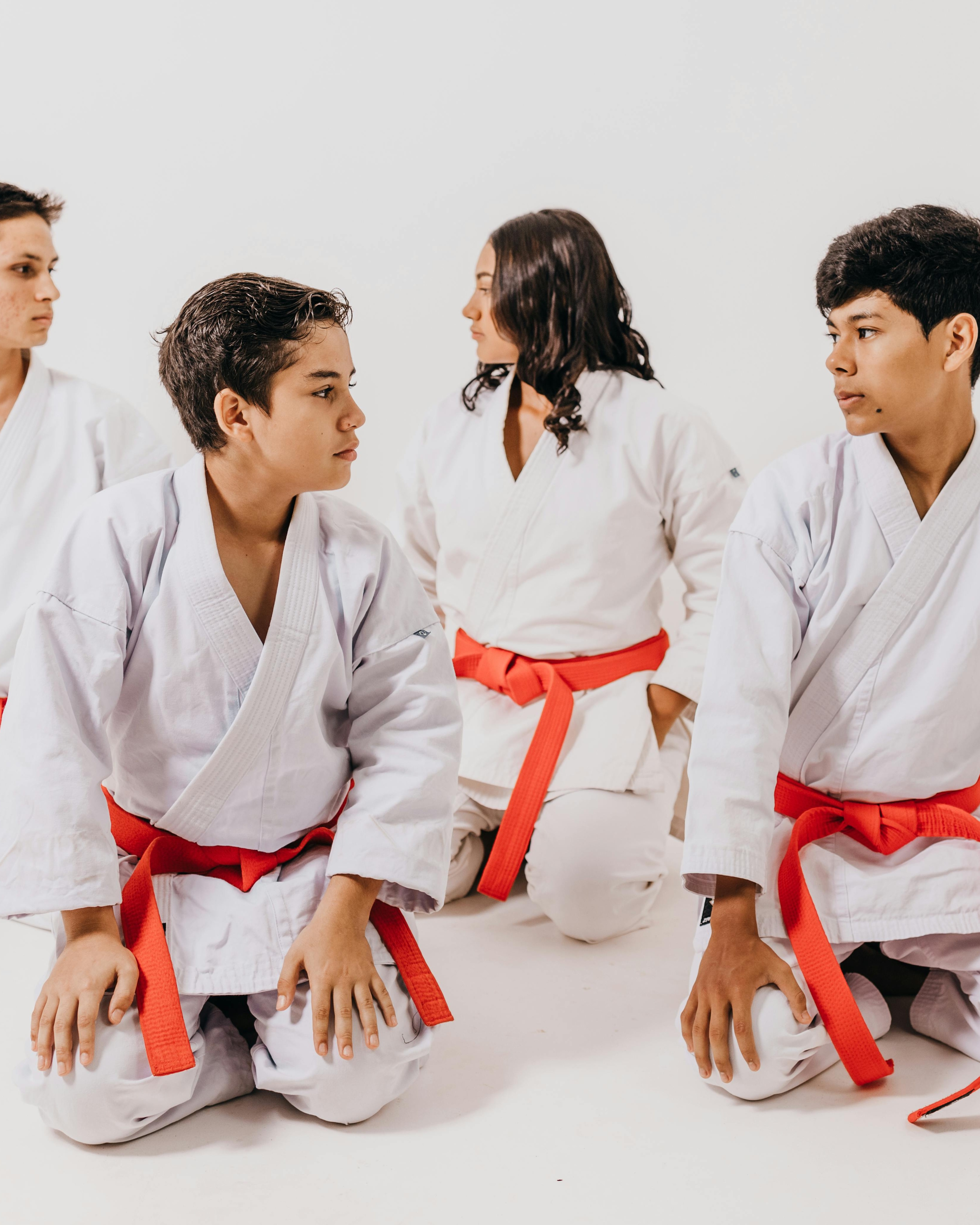 Four Young Karate Students Kneeling