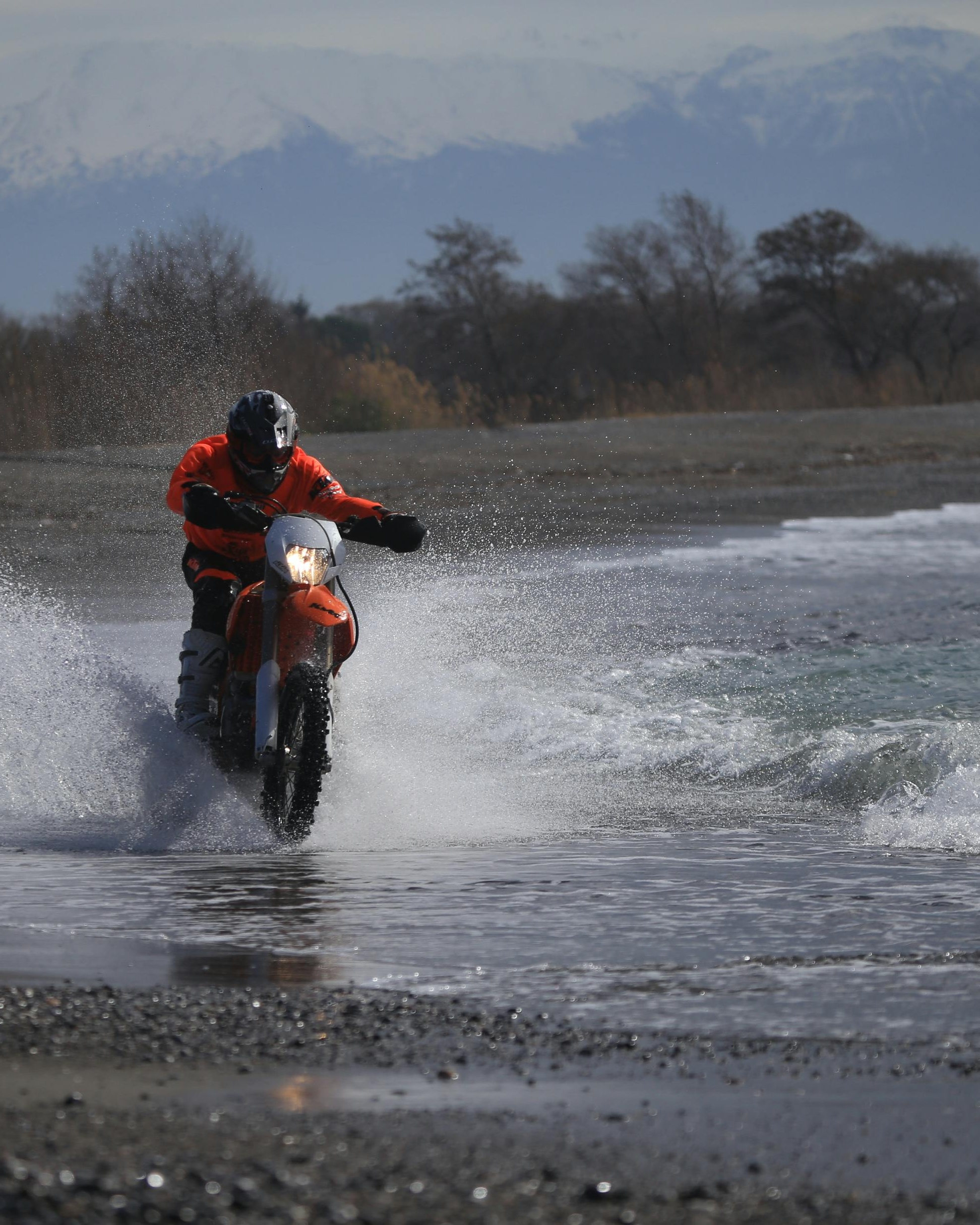 Dirt Biker Riding Through Shallow Shore Water
