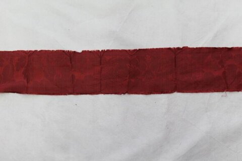 Red Patterned Fabric Strip on White Background