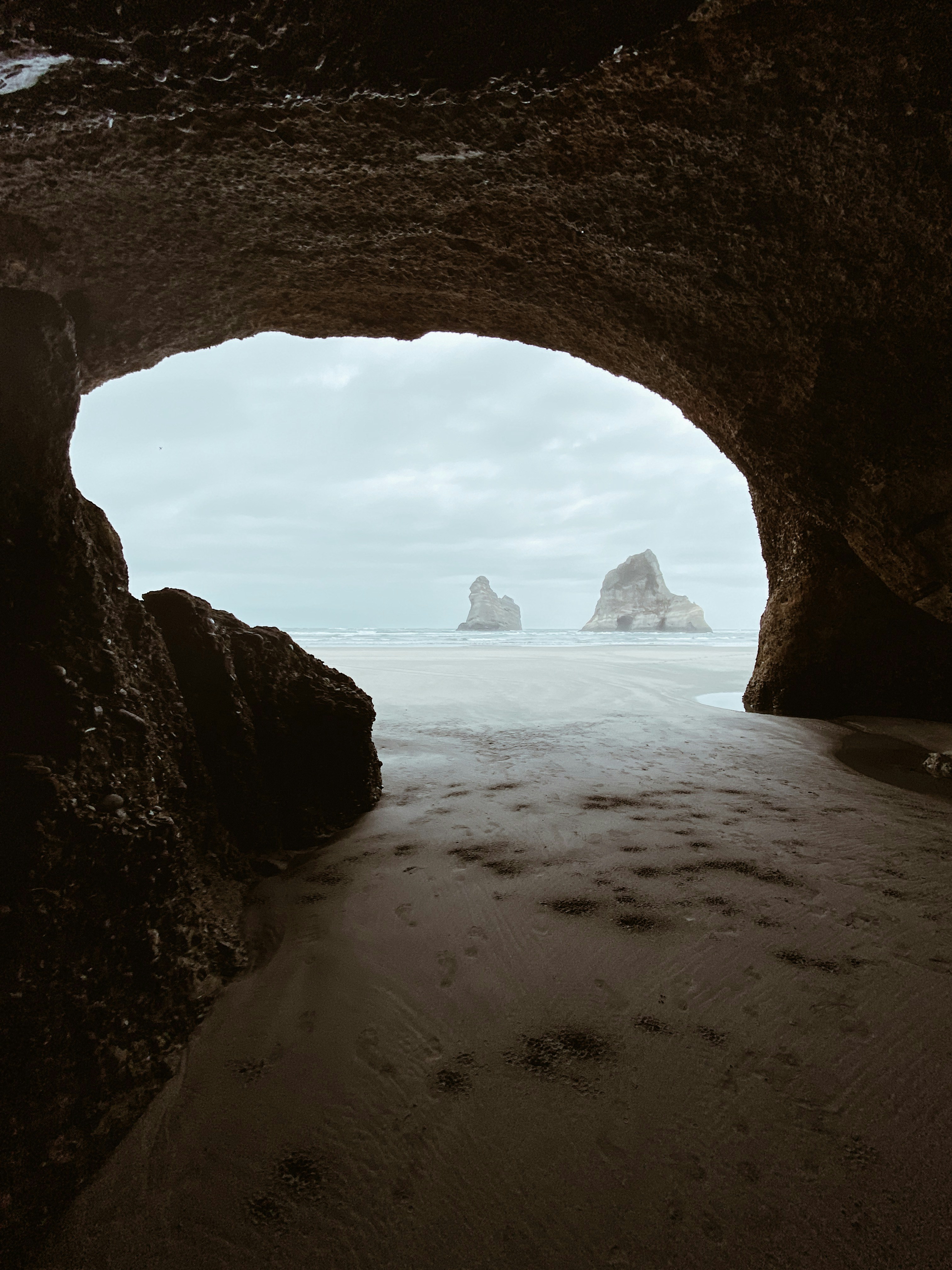 Cave View of Coastal Beach and Sea Stacks