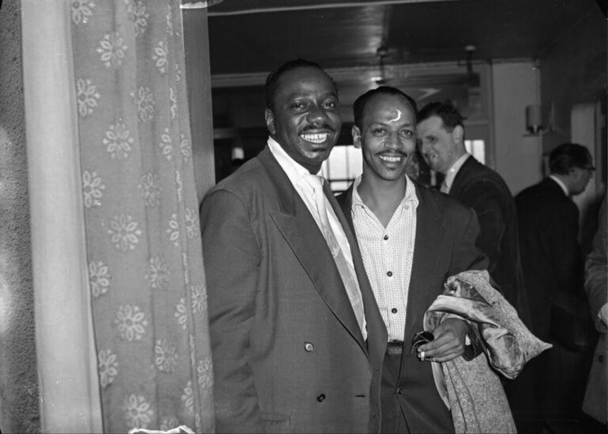 Two Smiling Black Men At Indoor Gathering