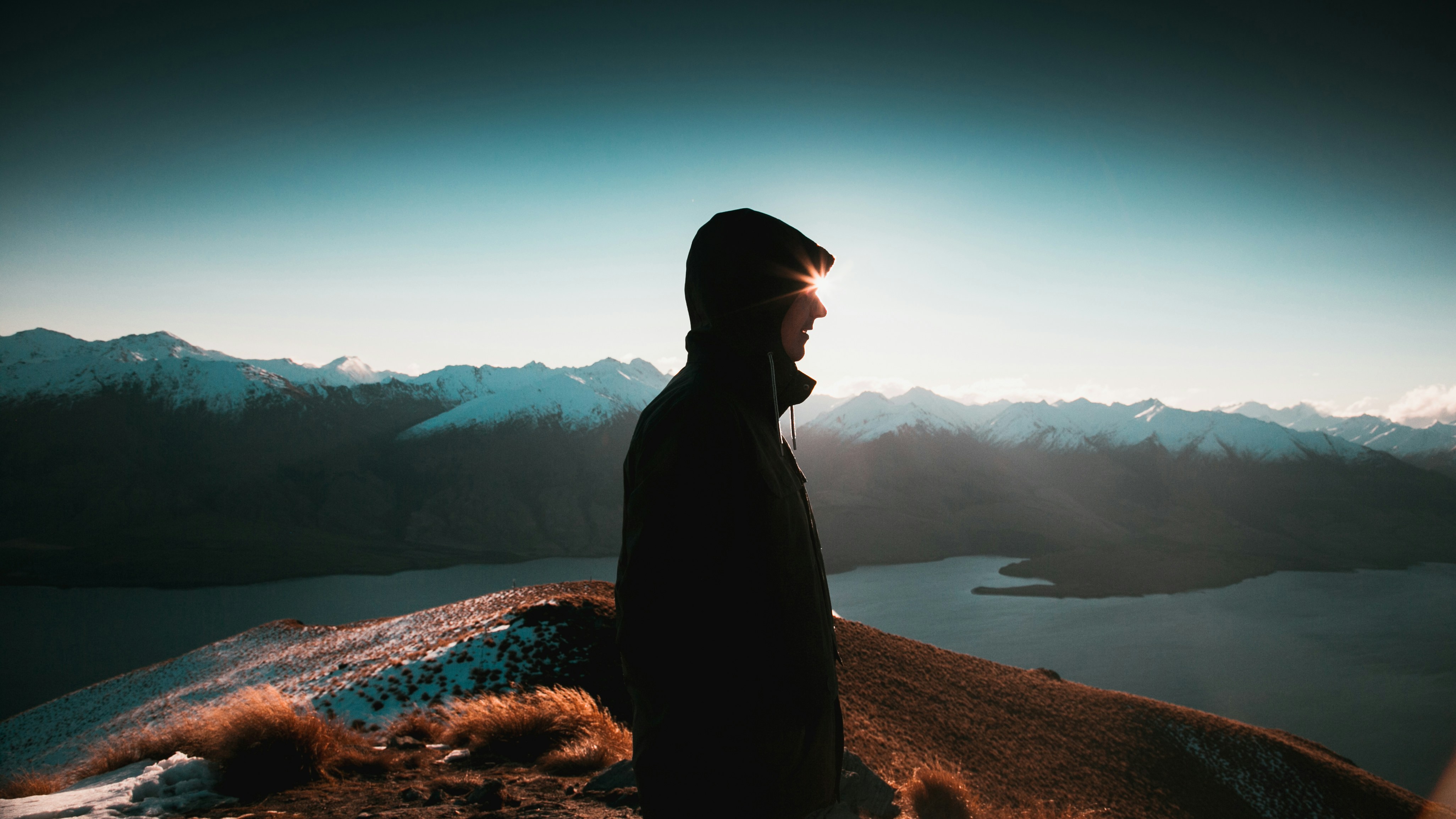 Hiker Overlooking Snow Mountain Lake
