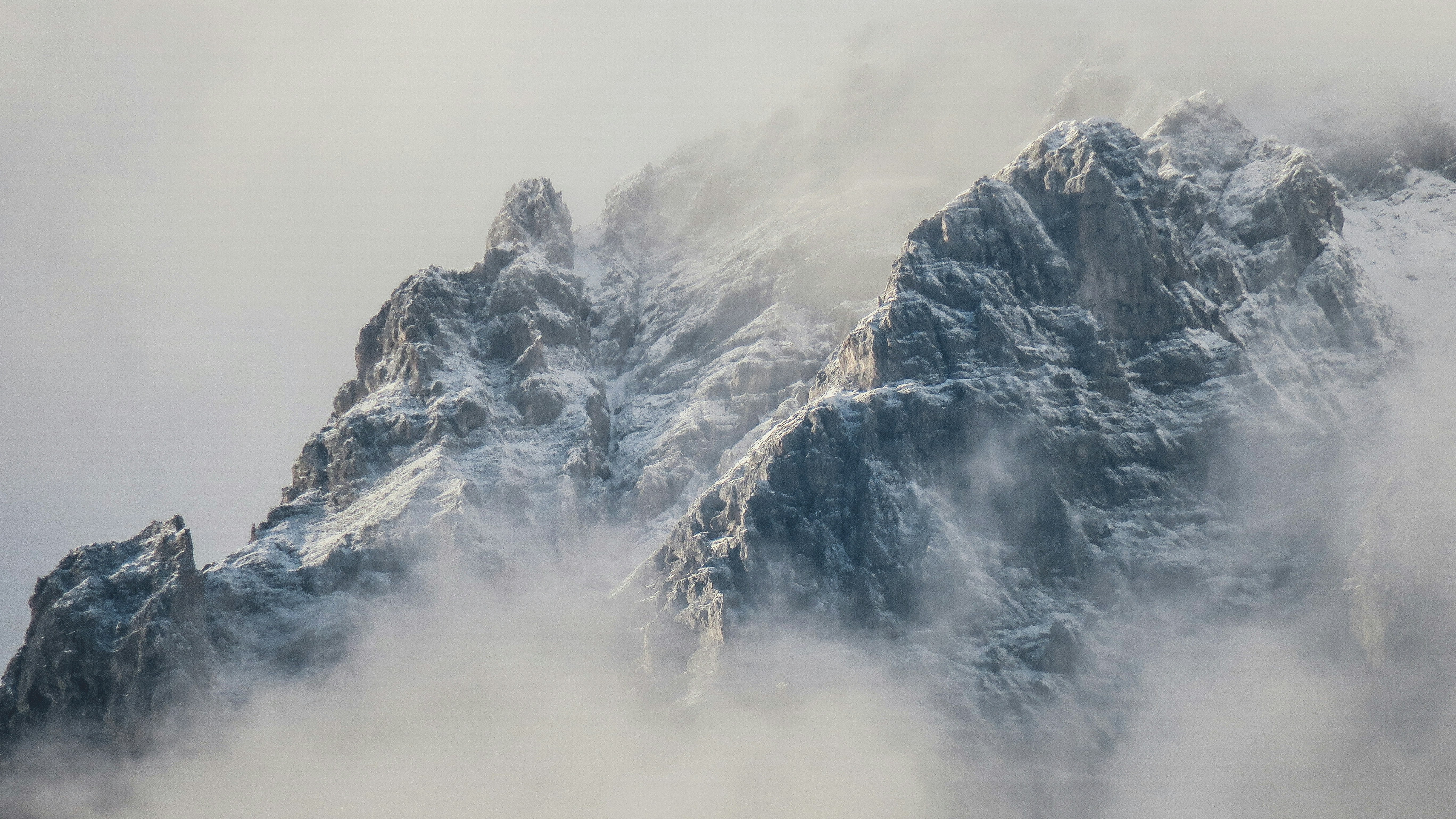 Snow Covered Mountain Peaks in Fog
