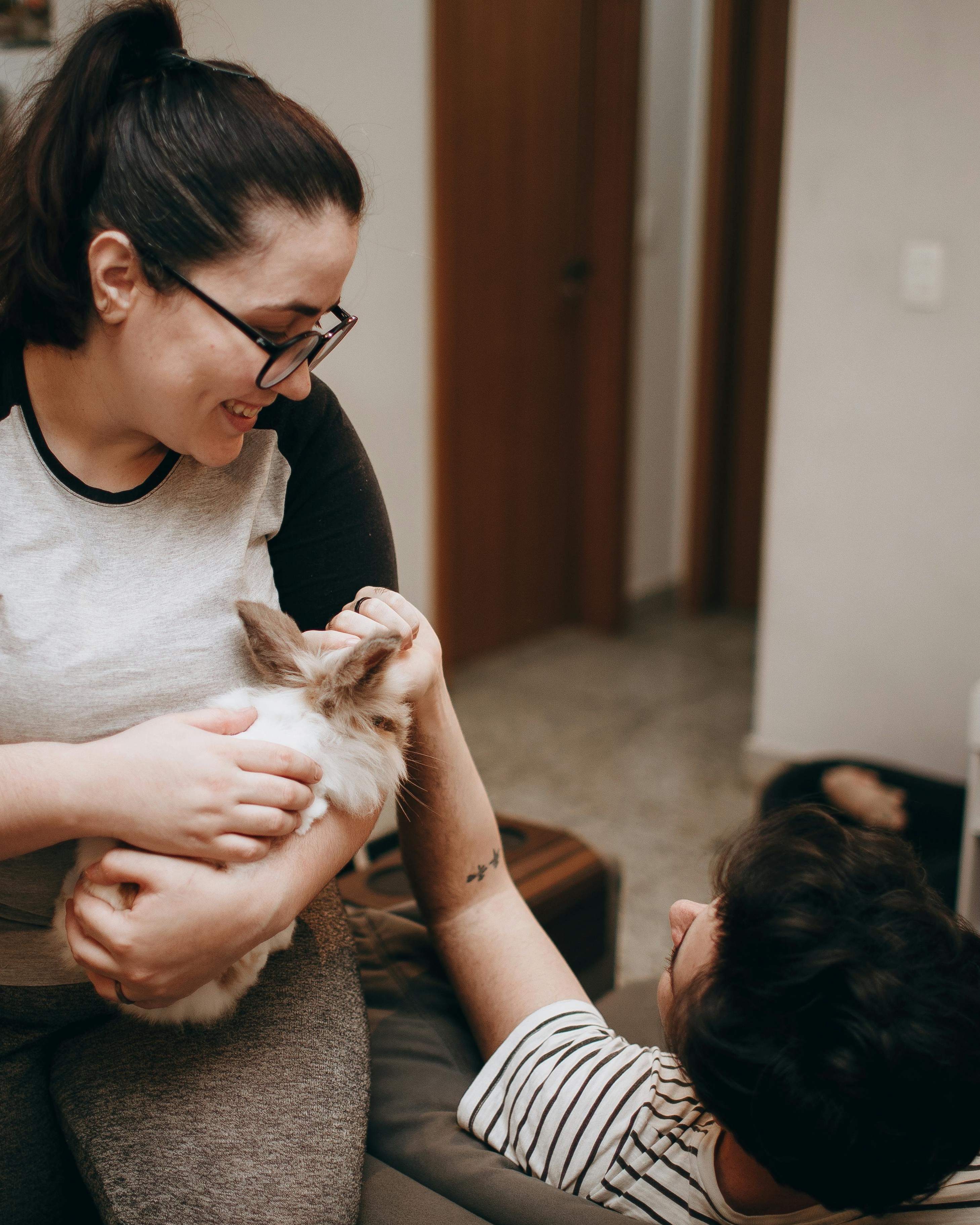 Two People Interacting With Pet Rabbit