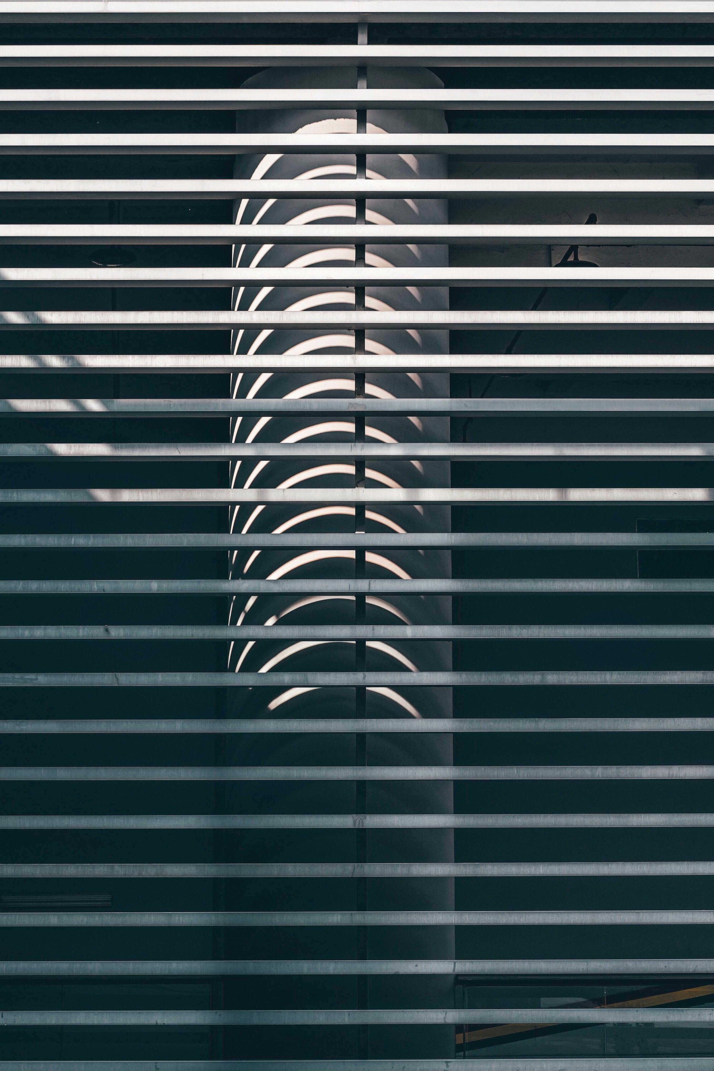 Curved Shadows on Column Behind Louvers