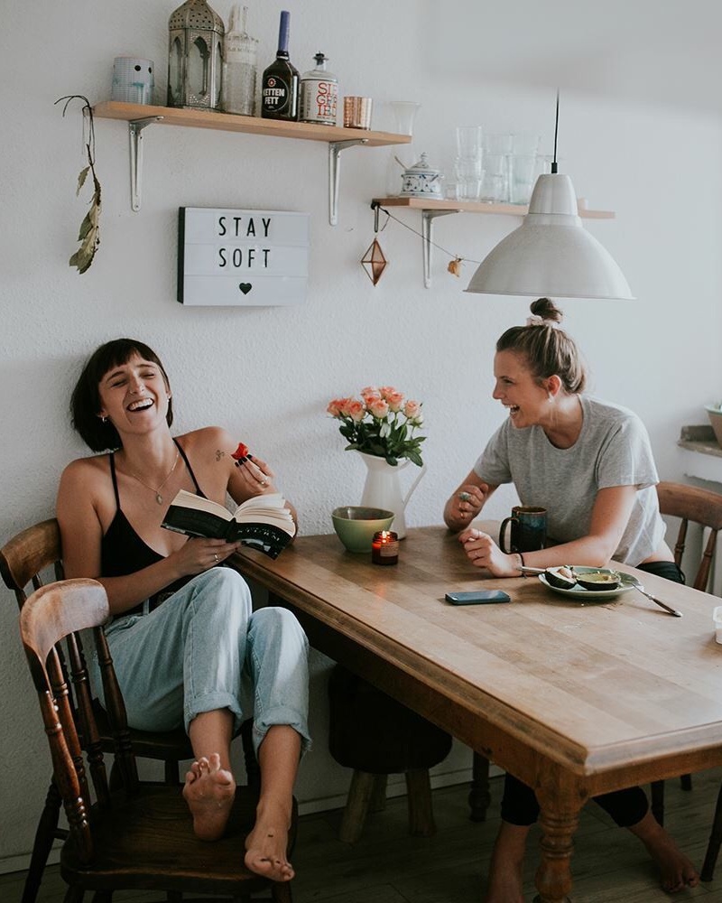 Two Women Laughing Together at Dining Table