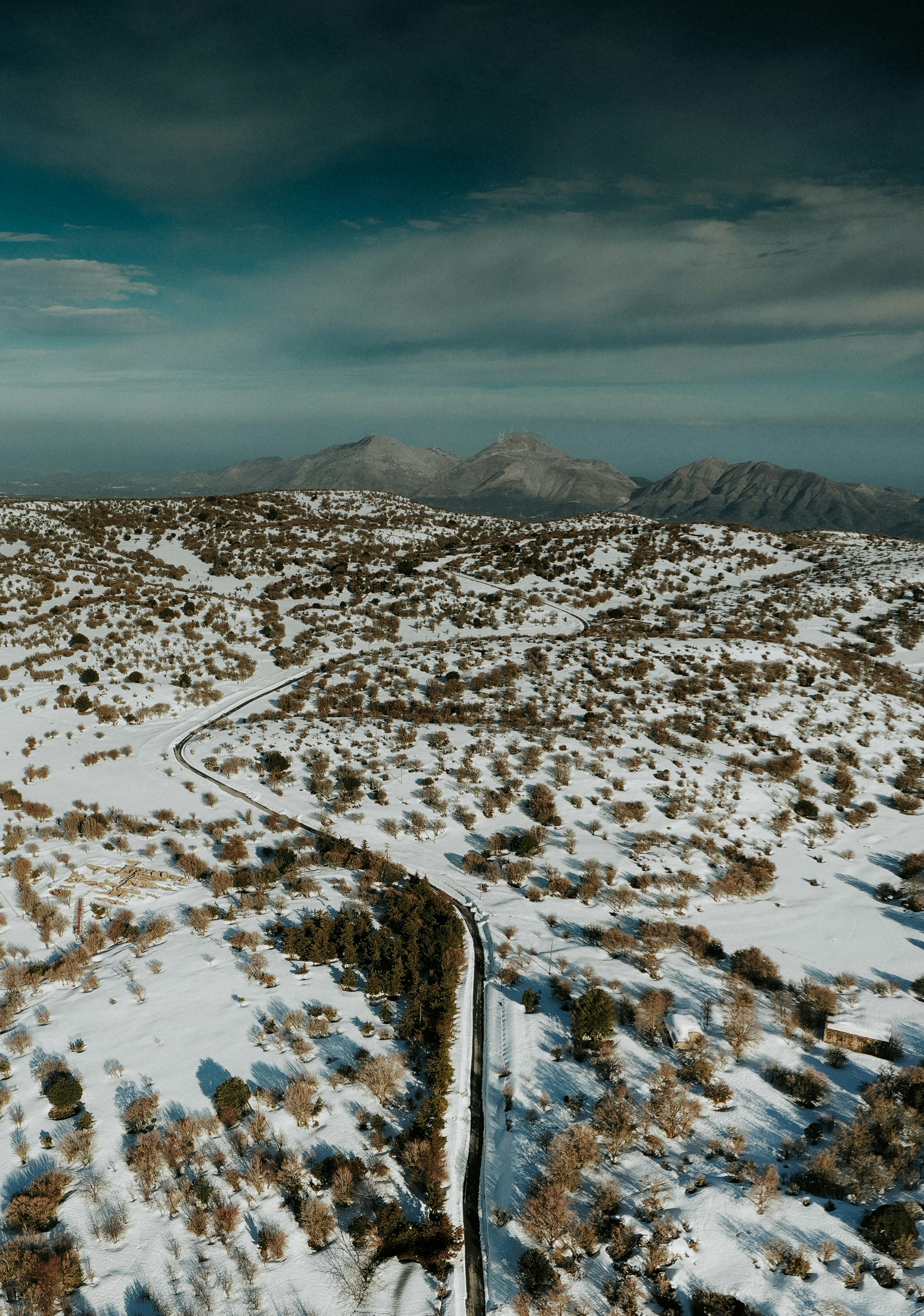 Winding Road Across Snowy Mountain Hills