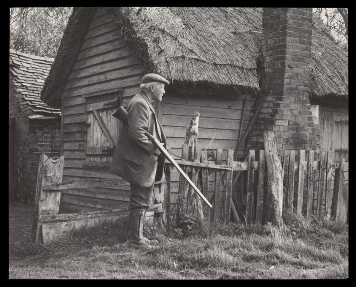 Elderly Hunter By Thatched Cottage