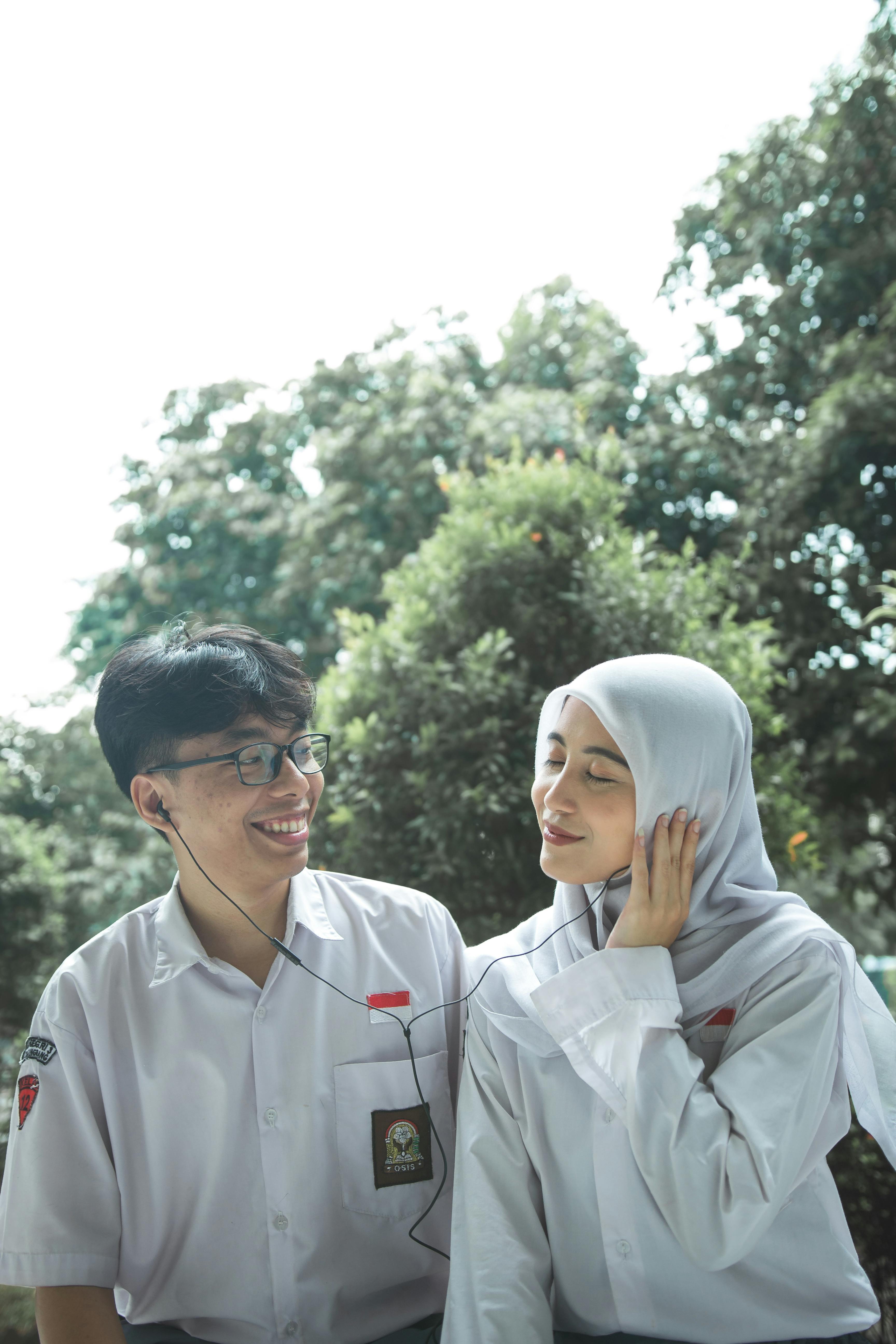 Two Students Sharing Earphones Outdoors