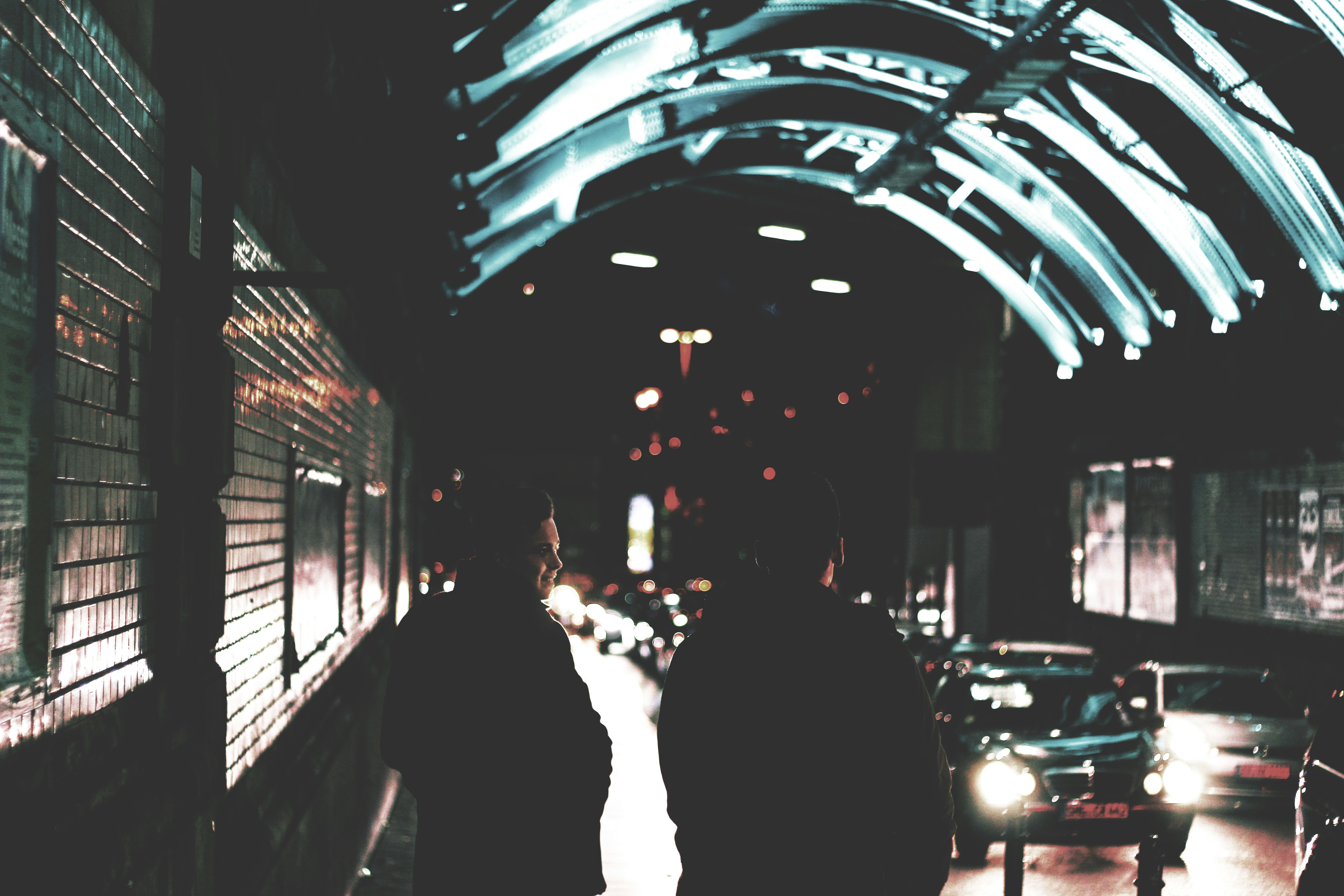 Two People Walking in Night Underpass