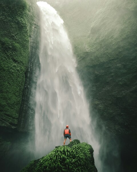Hiker Facing Tall Waterfall