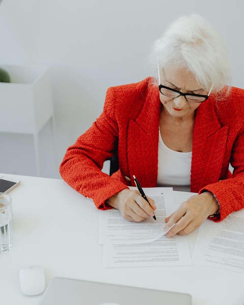 Senior Woman Signing Documents