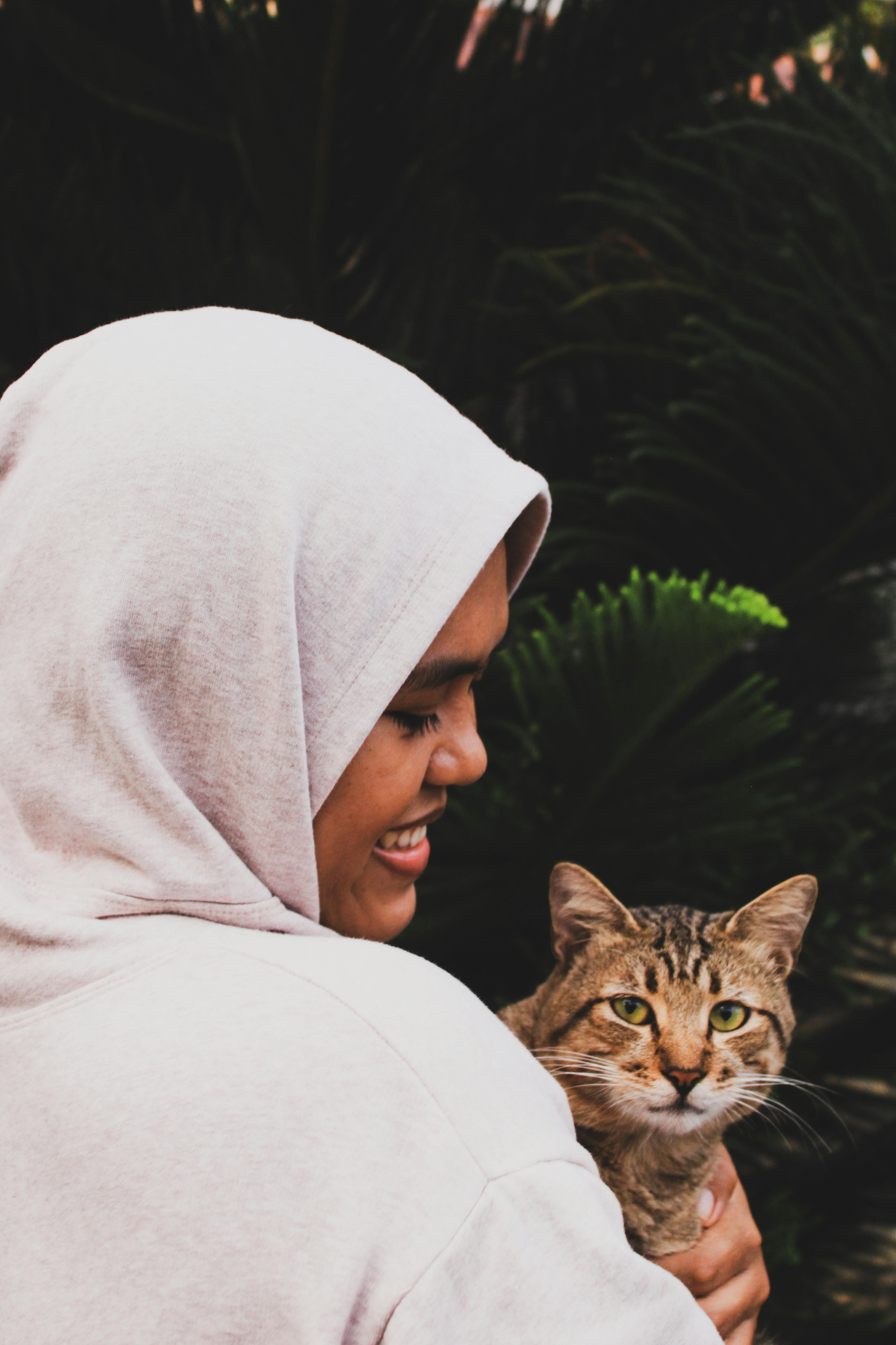 Woman in Hijab Holding Tabby Cat