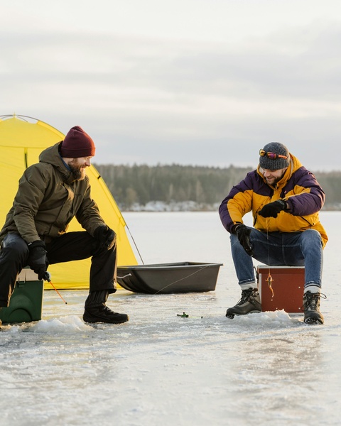Two Men Ice Fishing on Frozen Lake