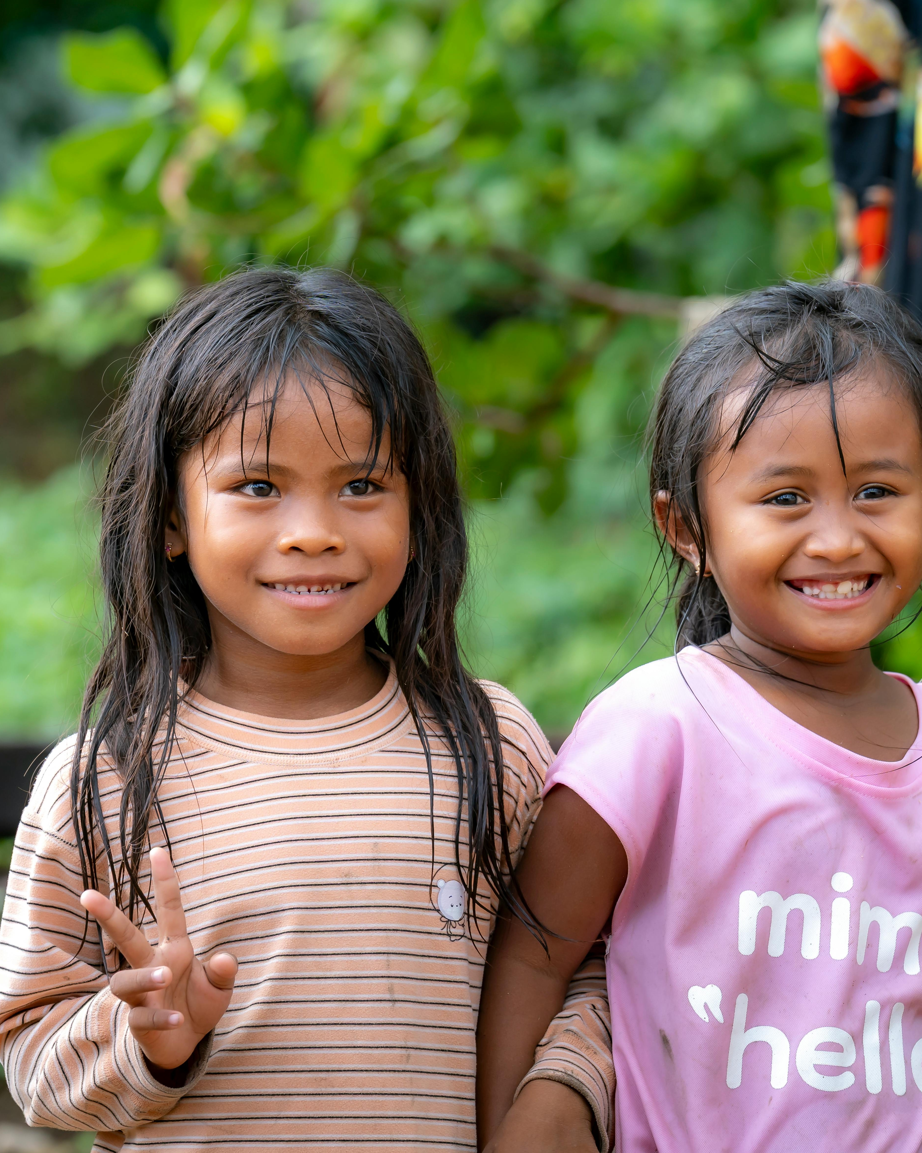 Two Young Smiling Girls Posing Outdoors
