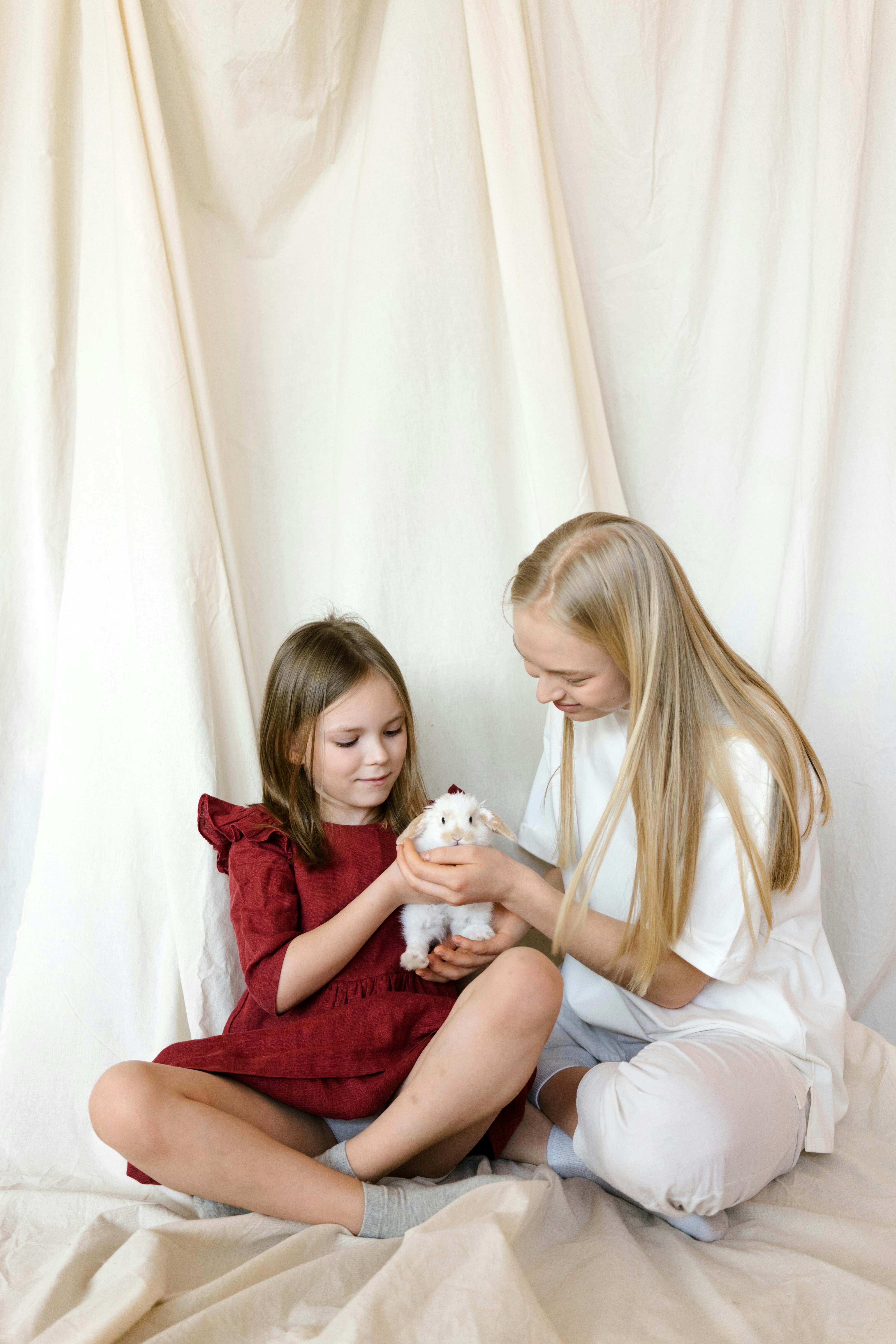 Two Girls Holding a Tiny White Bunny