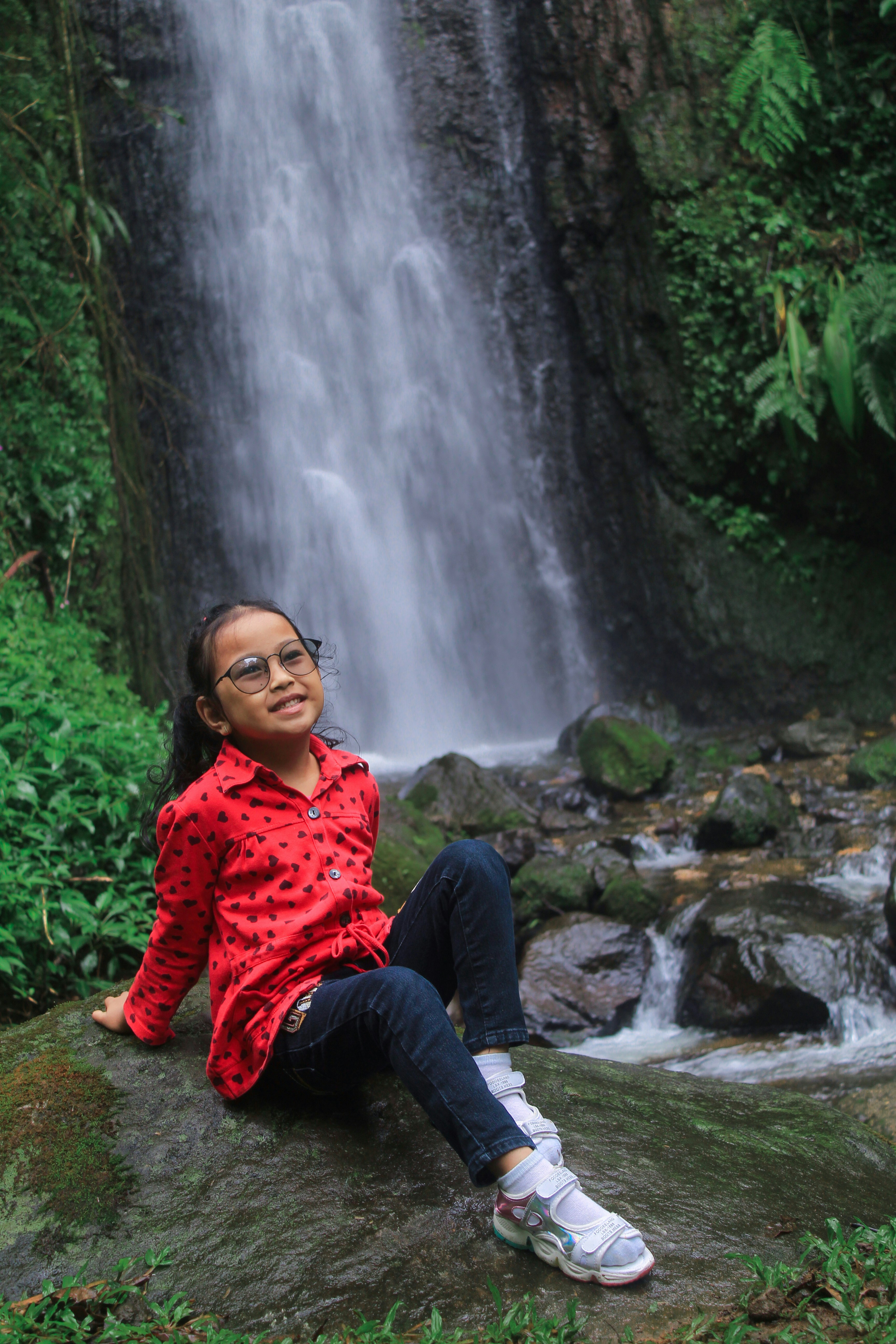 Girl Sitting By Forest Waterfall