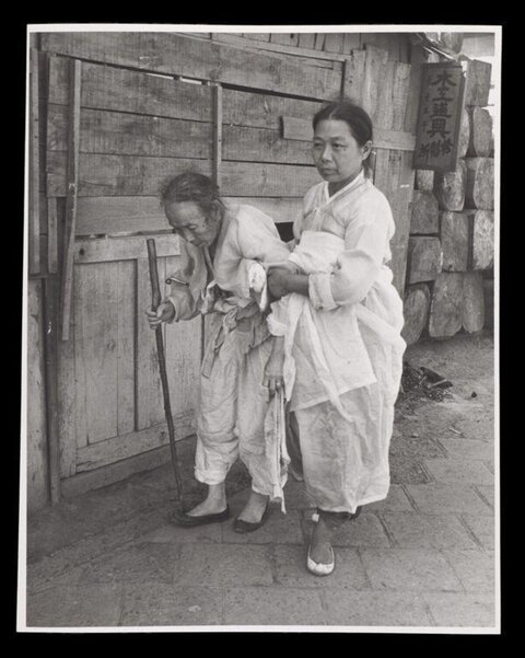 Woman Helping Elderly Woman on Street
