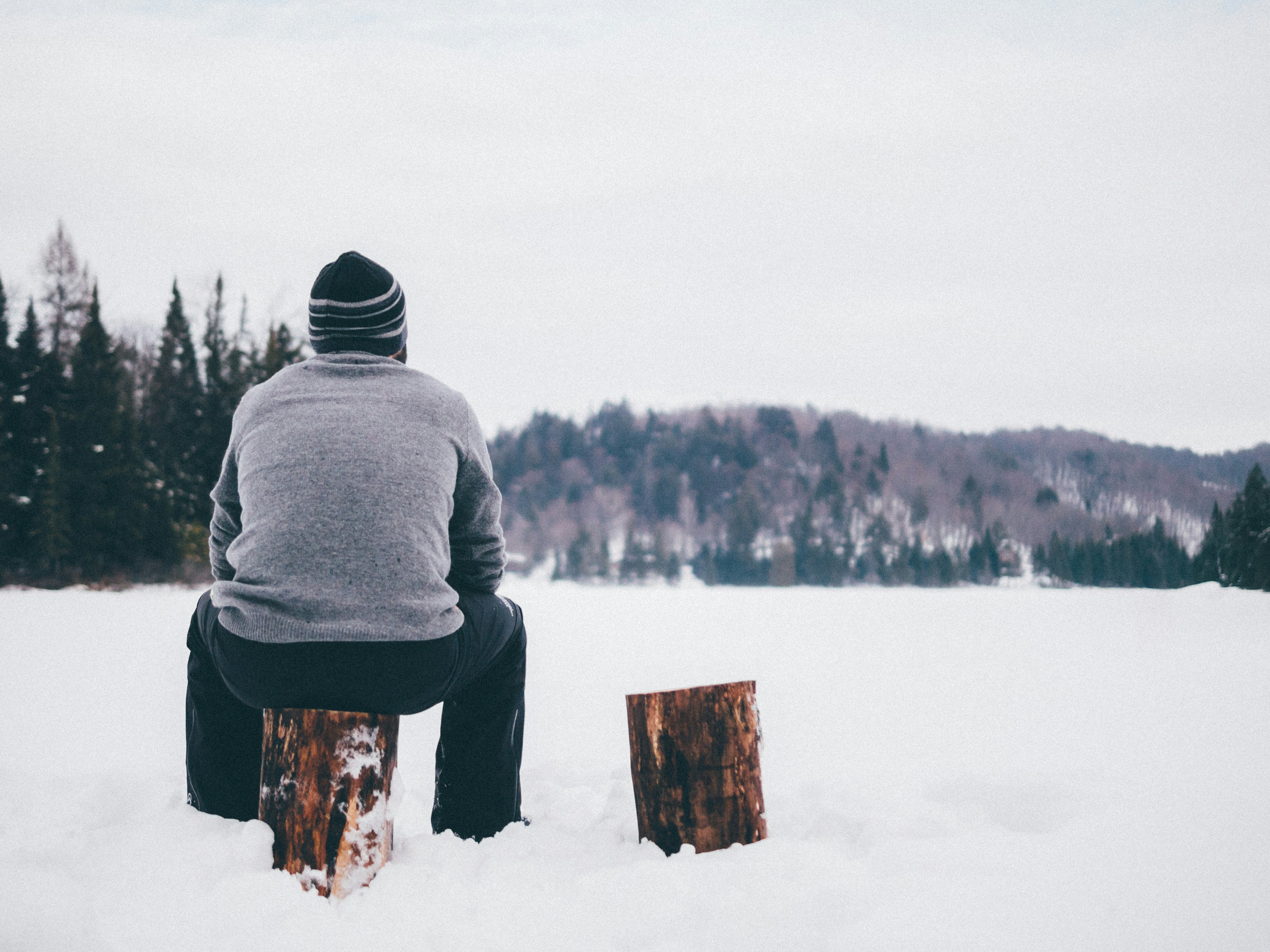 Man Sitting Alone on Frozen Lake