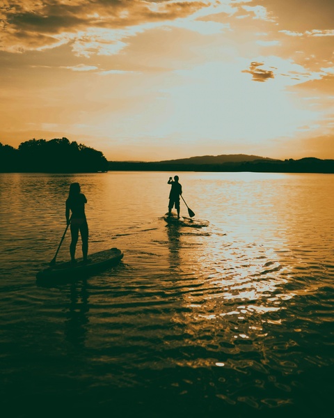 Two People Paddleboarding at Sunset