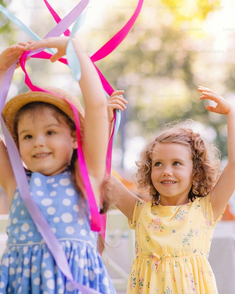 Two Girls Playing With Colorful Ribbons Outdoors