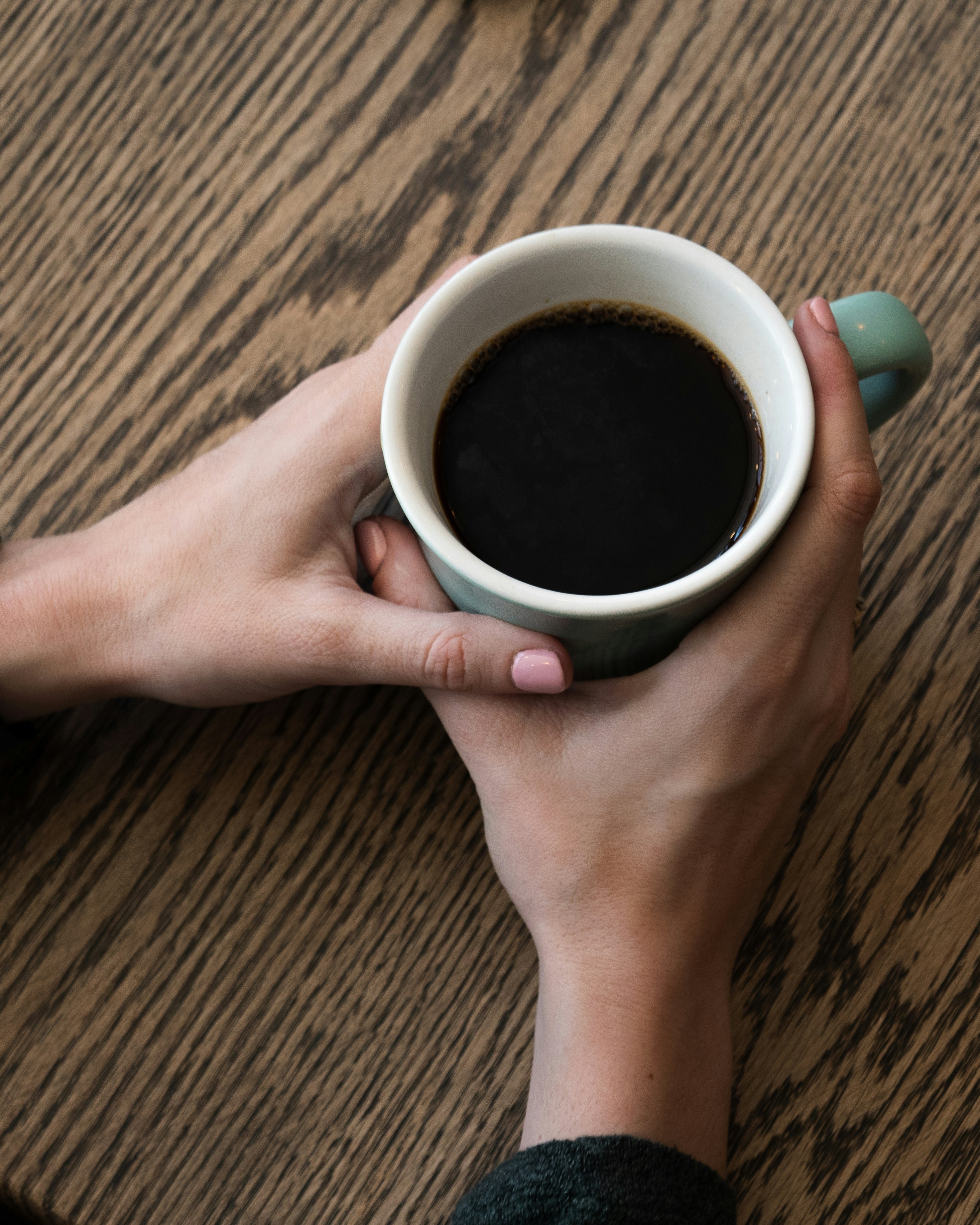 Hands Holding Black Coffee Mug
