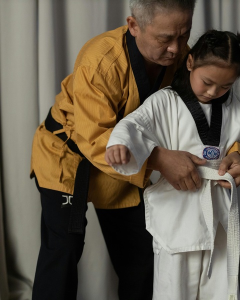 Taekwondo Instructor Helping Young Student