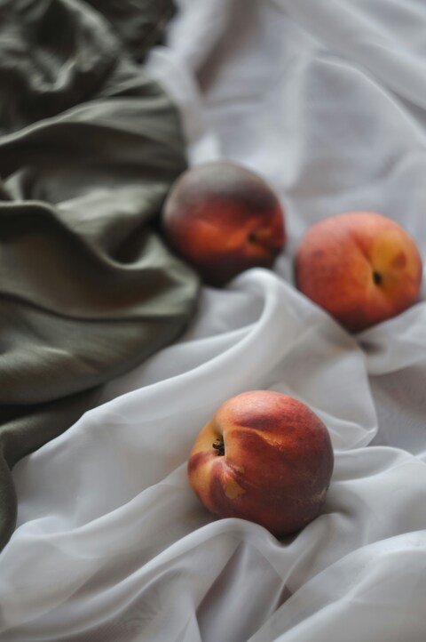 Three Peaches on Wrinkled Fabric
