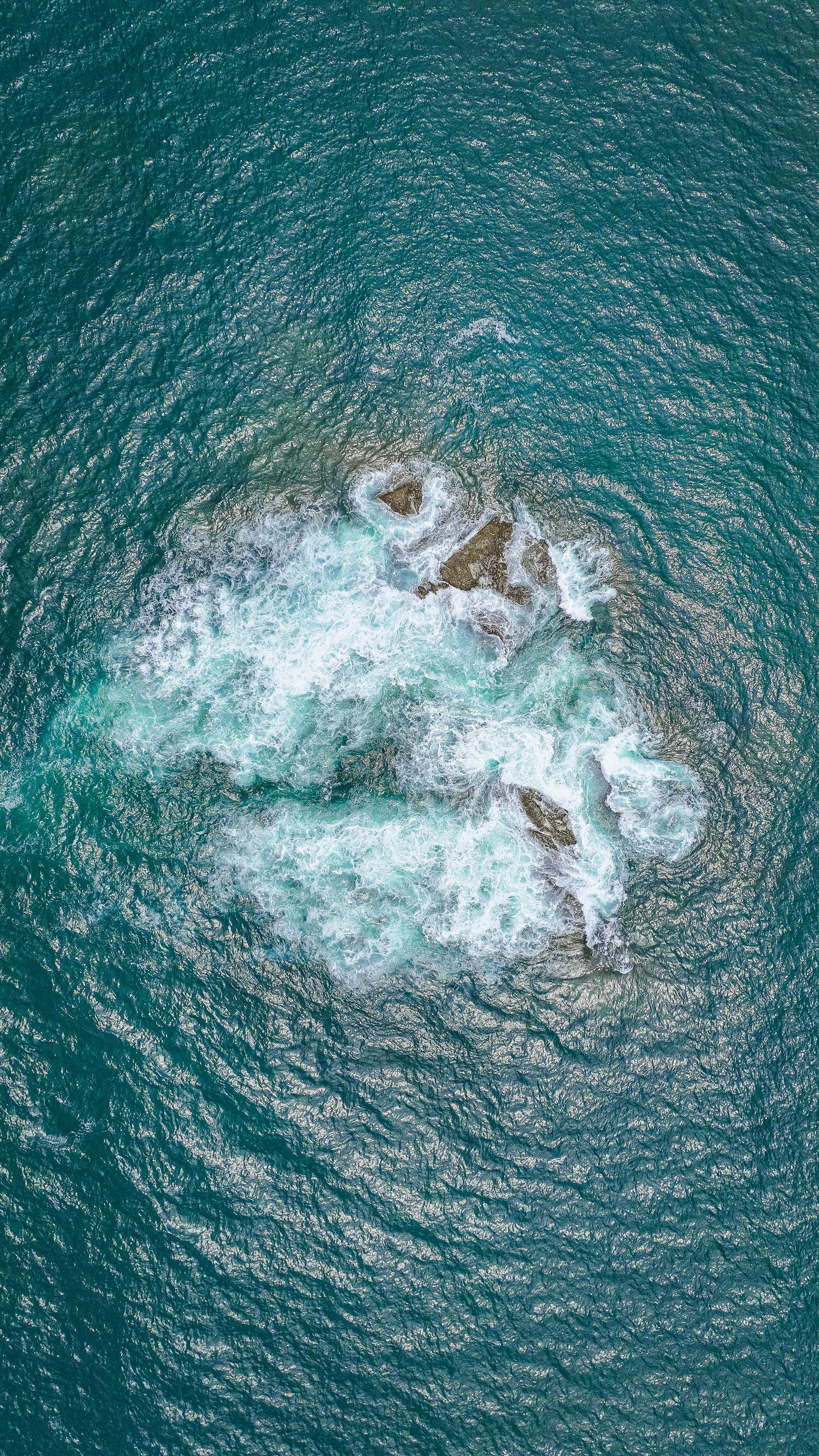 Aerial View of Waves Hitting Rocks