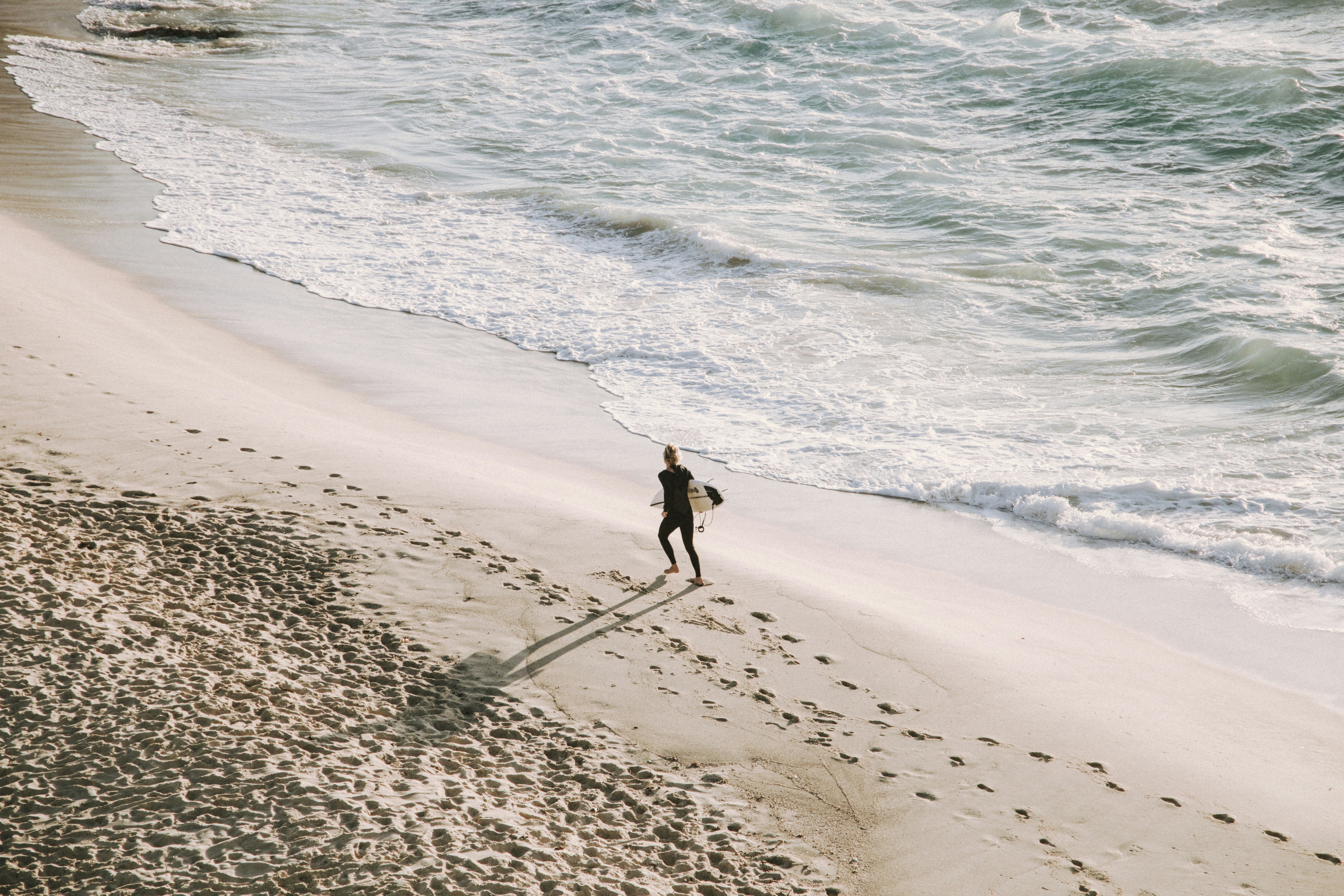 Surfer Walking Towards Ocean on Beach