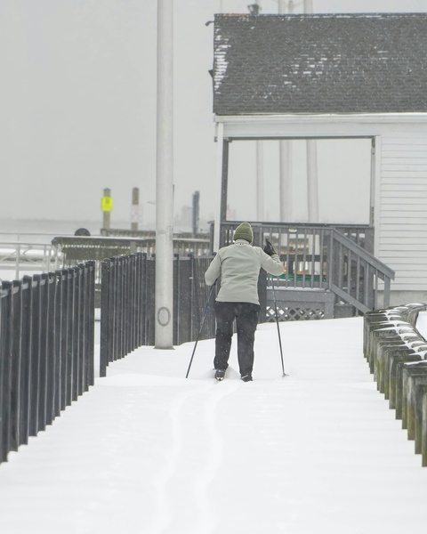 Cross-Country Skier on Snowy Pier