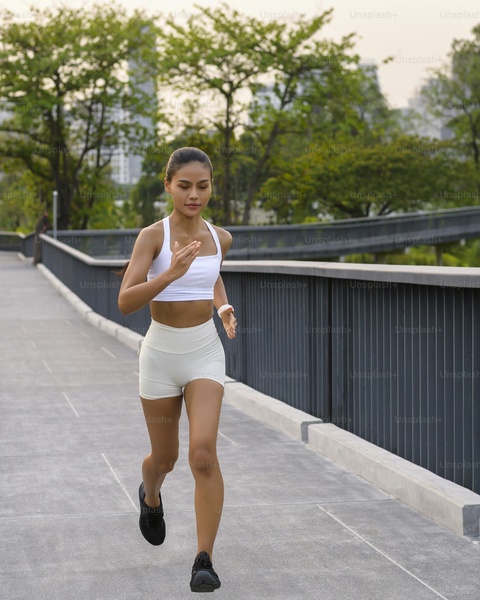 Woman Jogging on Urban Park Walkway
