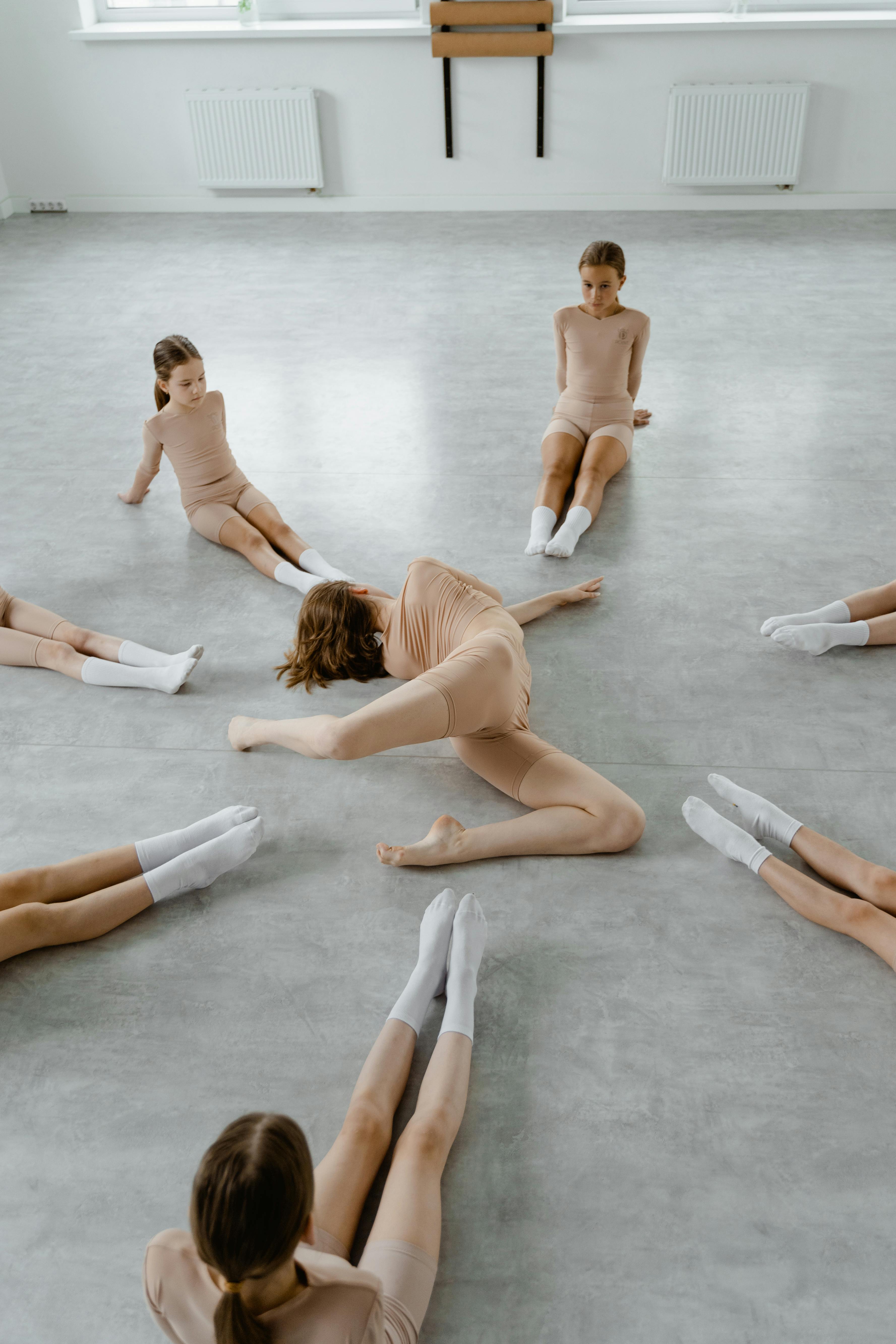 Dance Teacher Demonstrates Stretch to Students