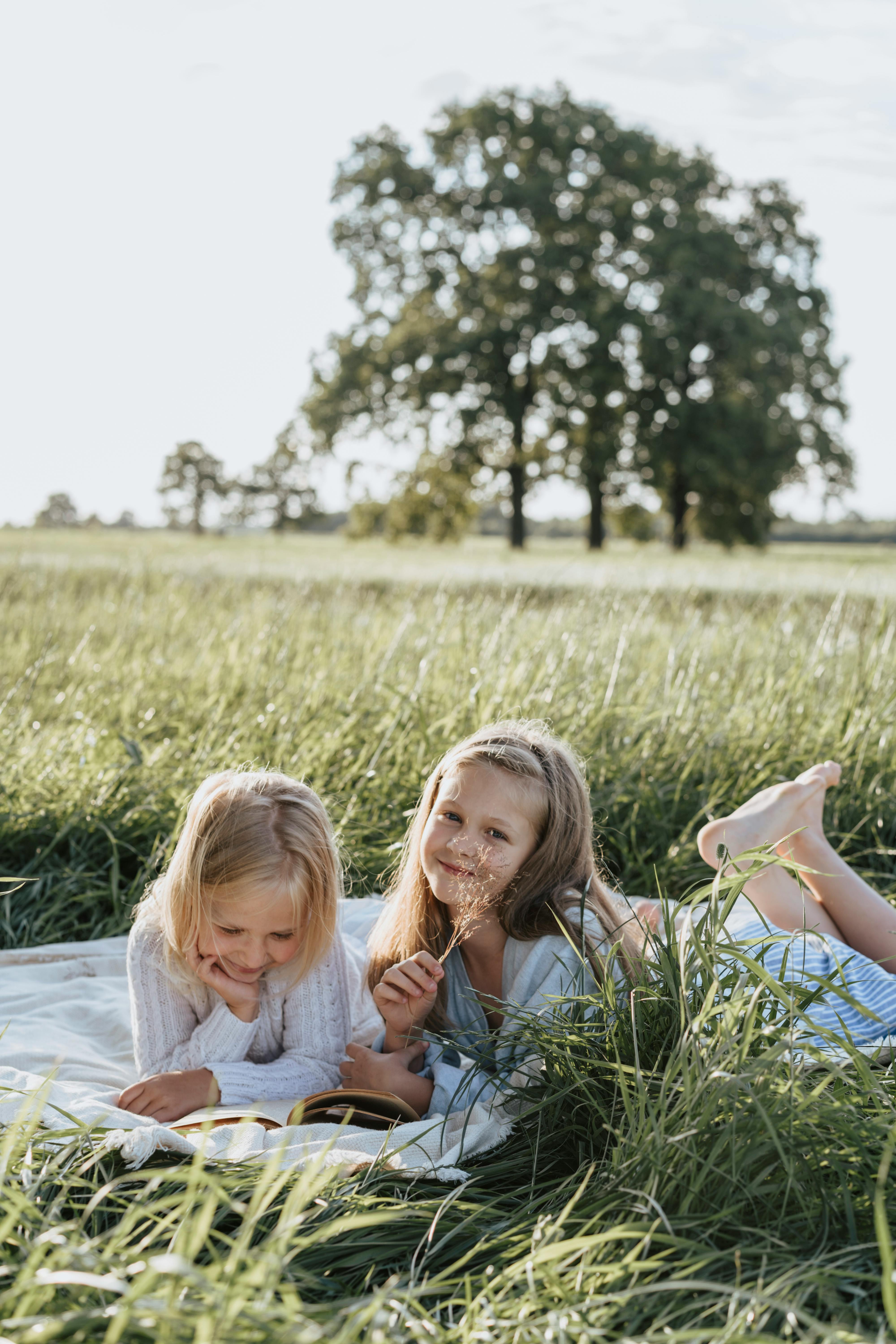 Two Girls Reading in Summer Meadow