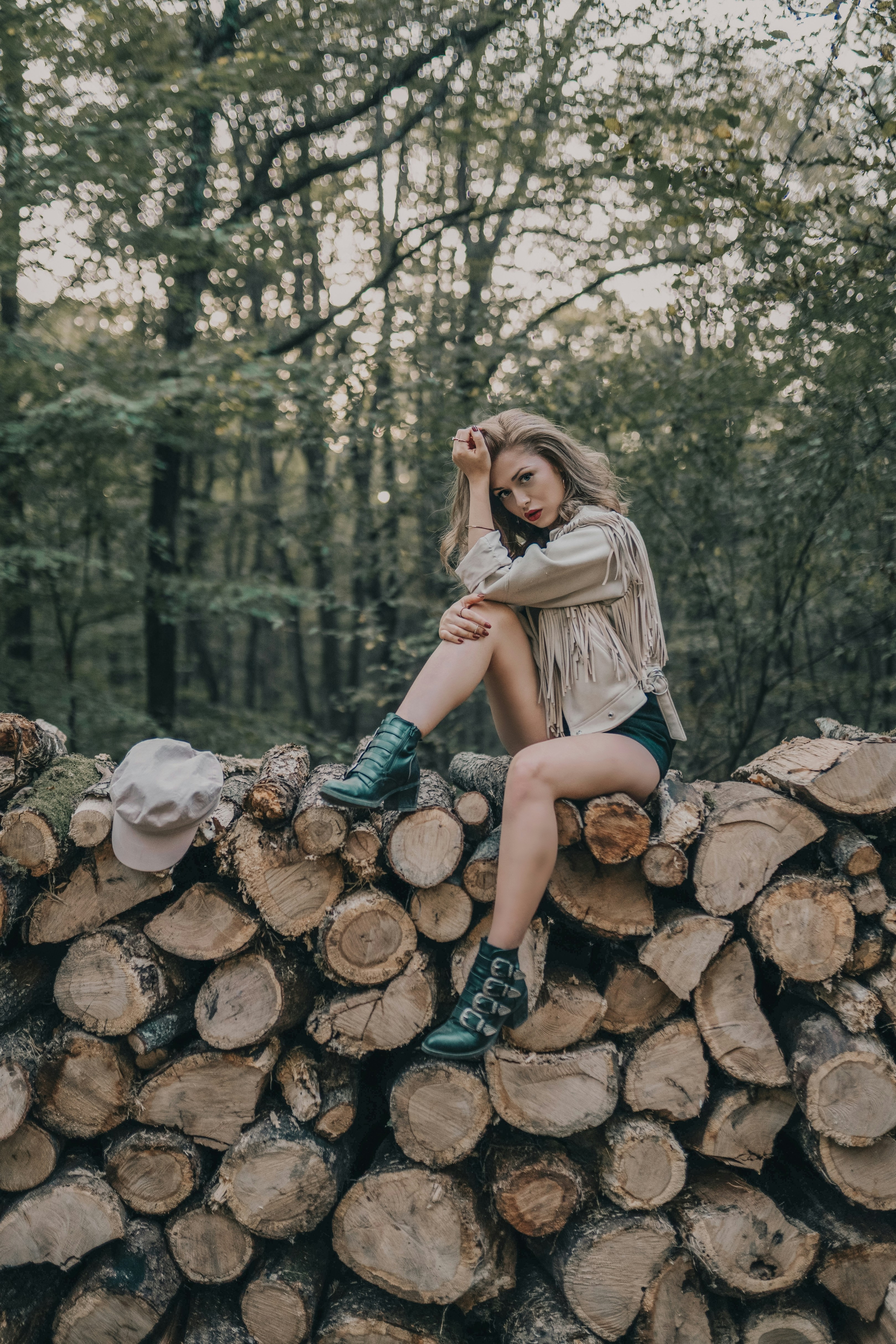 Woman Posing On Log Pile In Forest