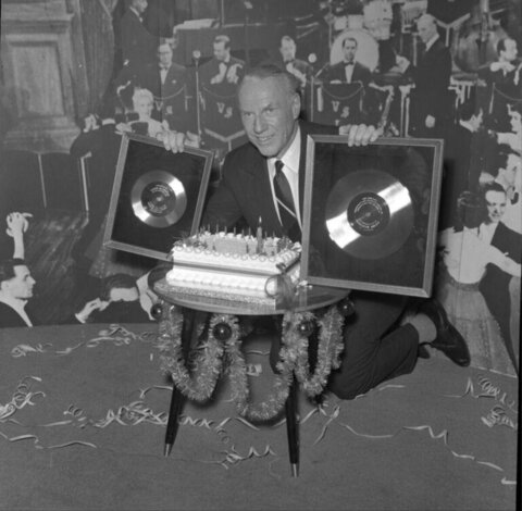 Man Displaying Two Gold Records at Celebration