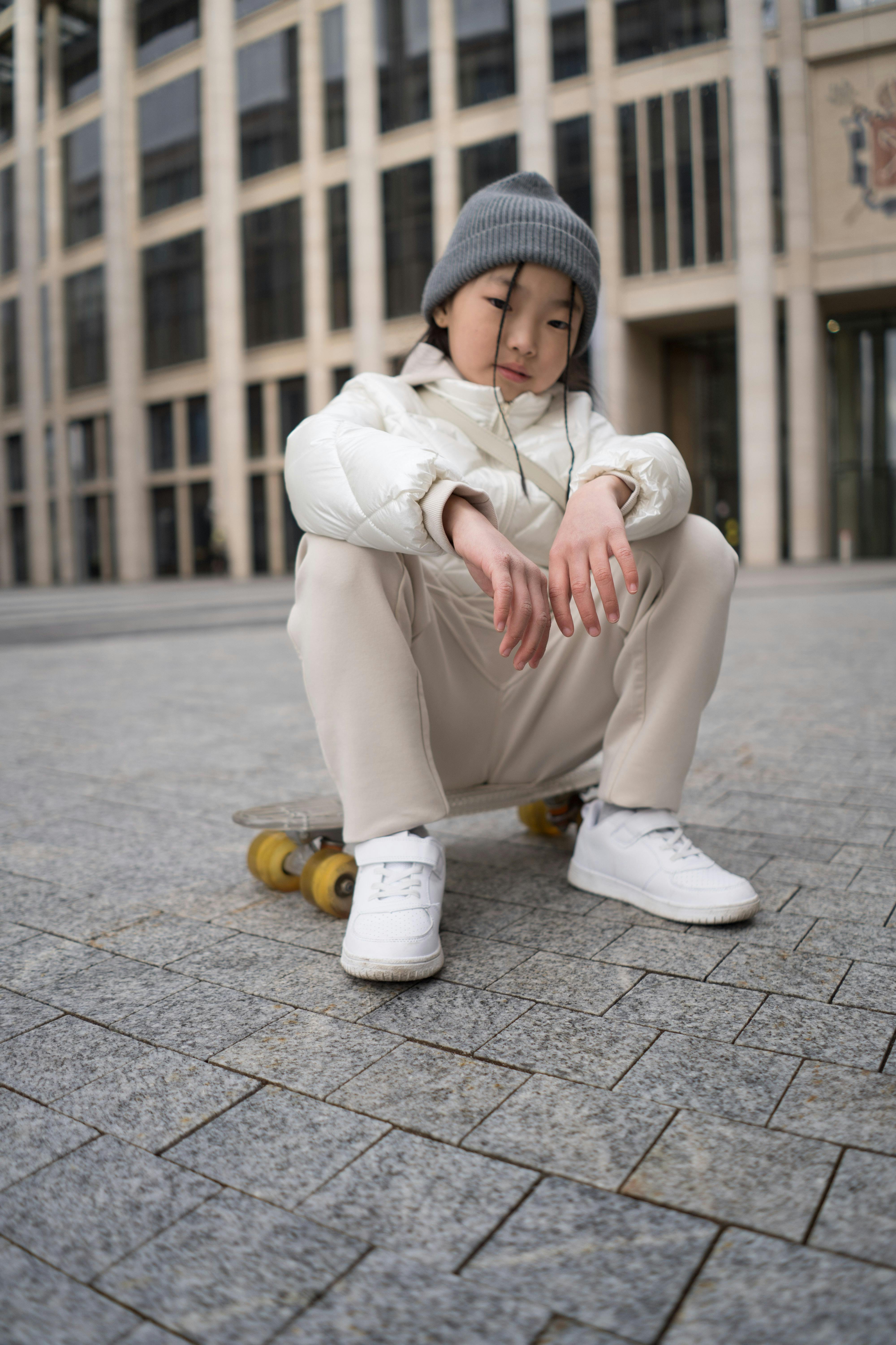 Girl Crouching on Skateboard in Urban Plaza
