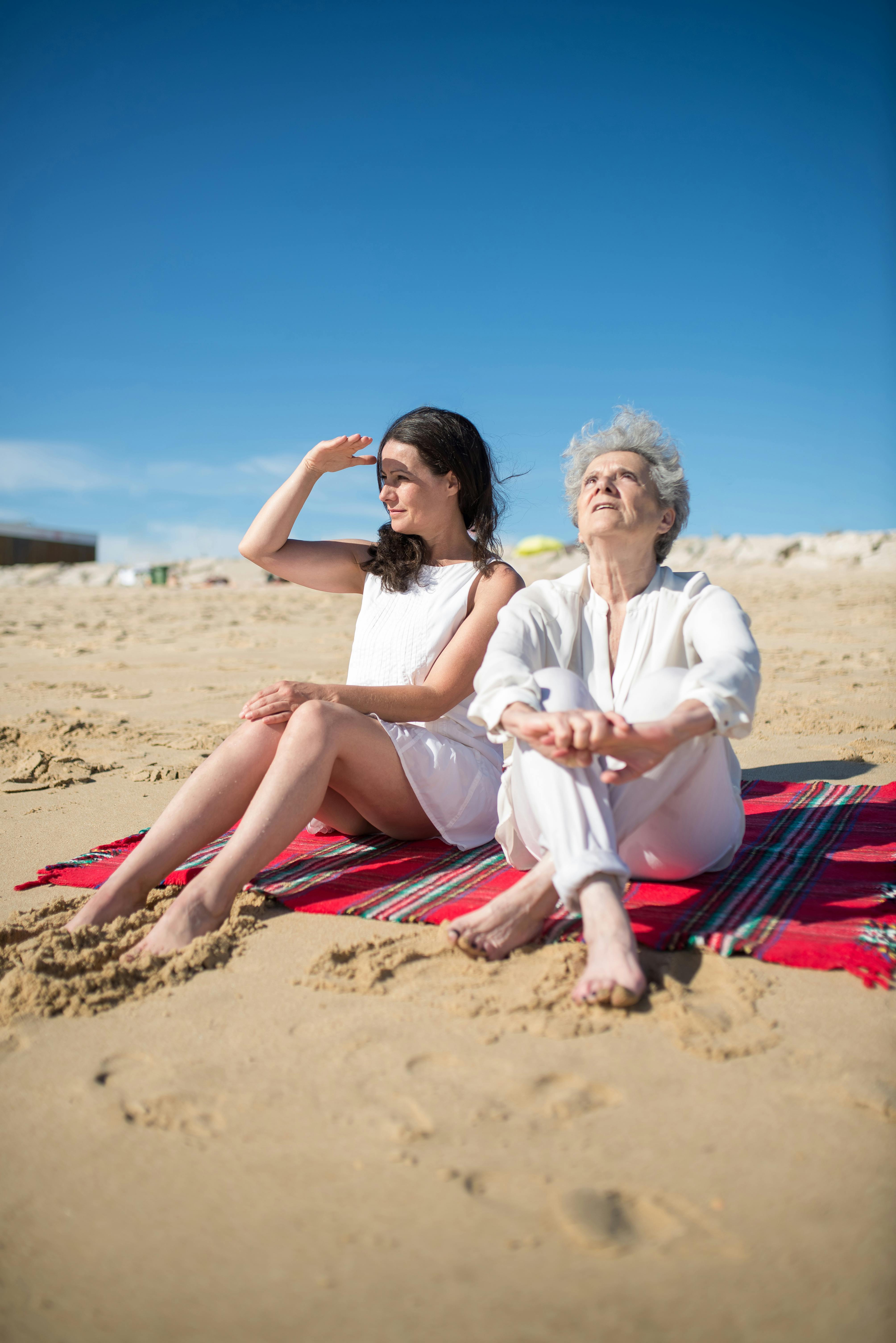 Two Women Relaxing On Sandy Beach