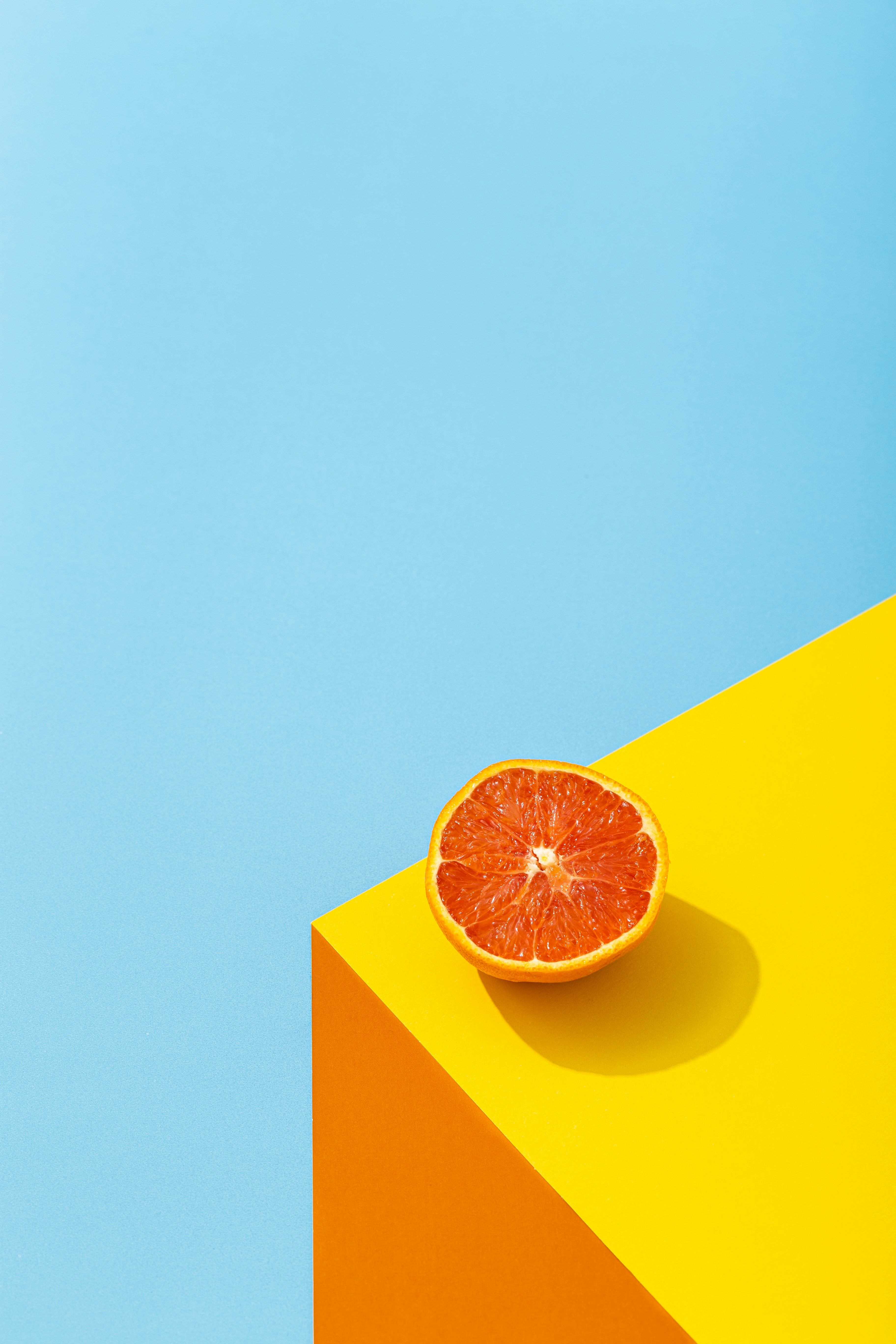 Halved Blood Orange on Colored Background — Phone Wallpapers