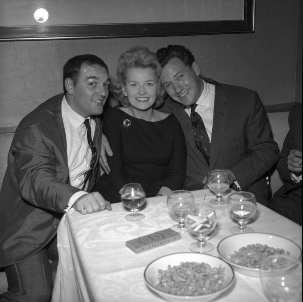 Three People Smiling At Dinner Table