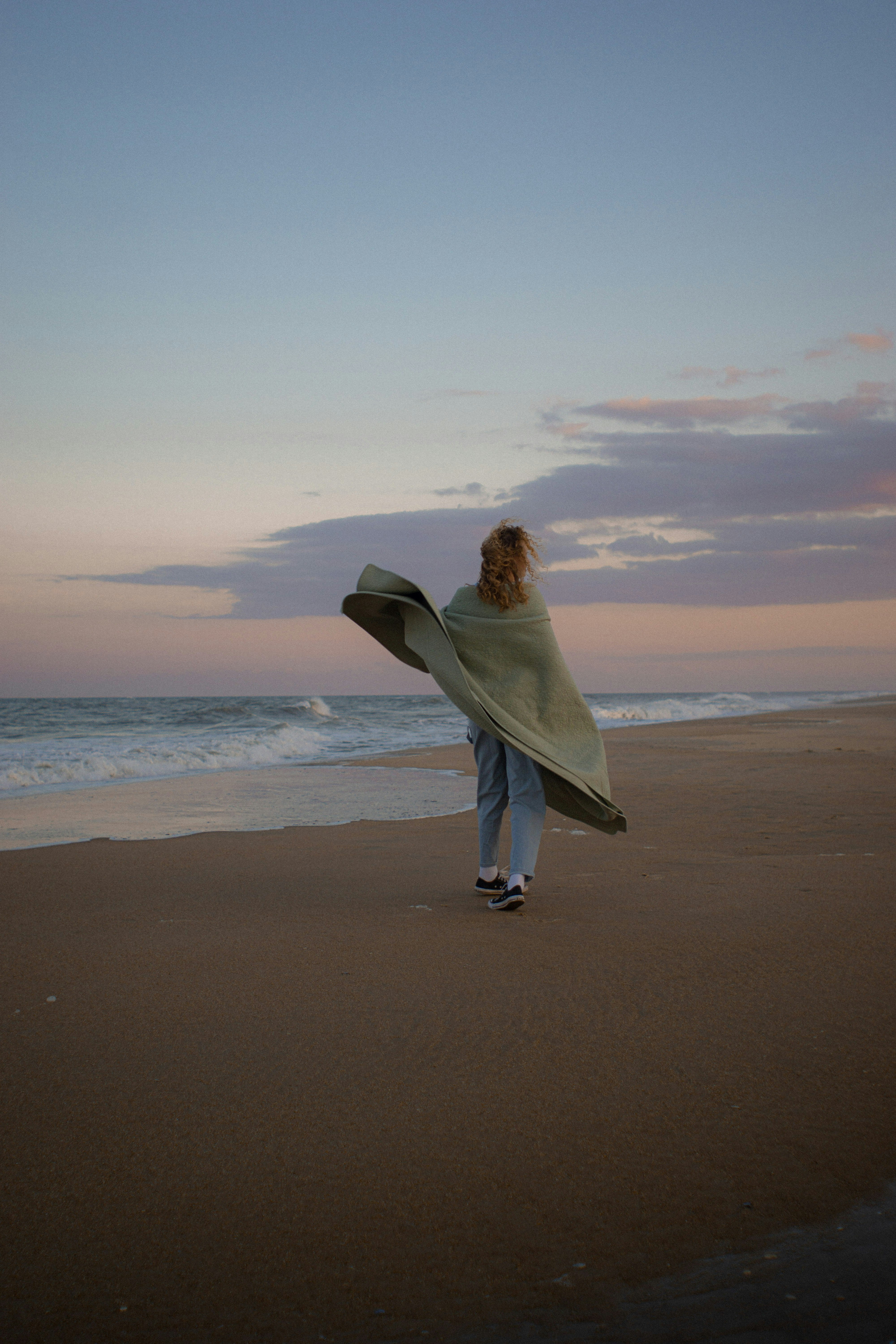 Woman Walking On Beach At Dusk