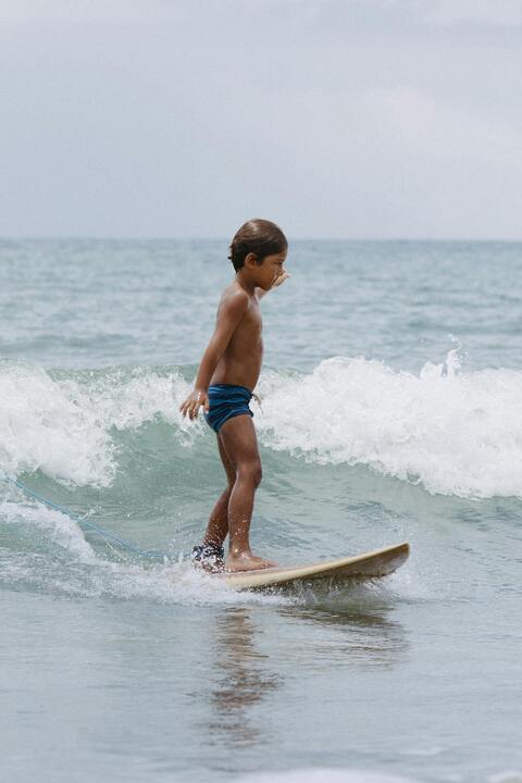 Young Boy Surfing on Ocean Wave