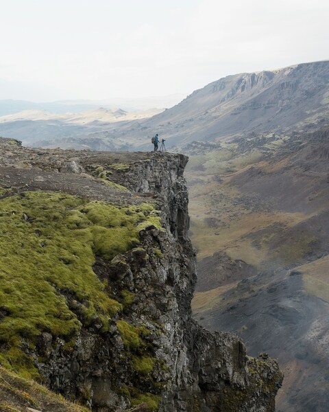 Photographer Standing on Mountain Cliff