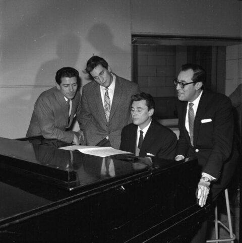 Four Men Gathered Around Grand Piano