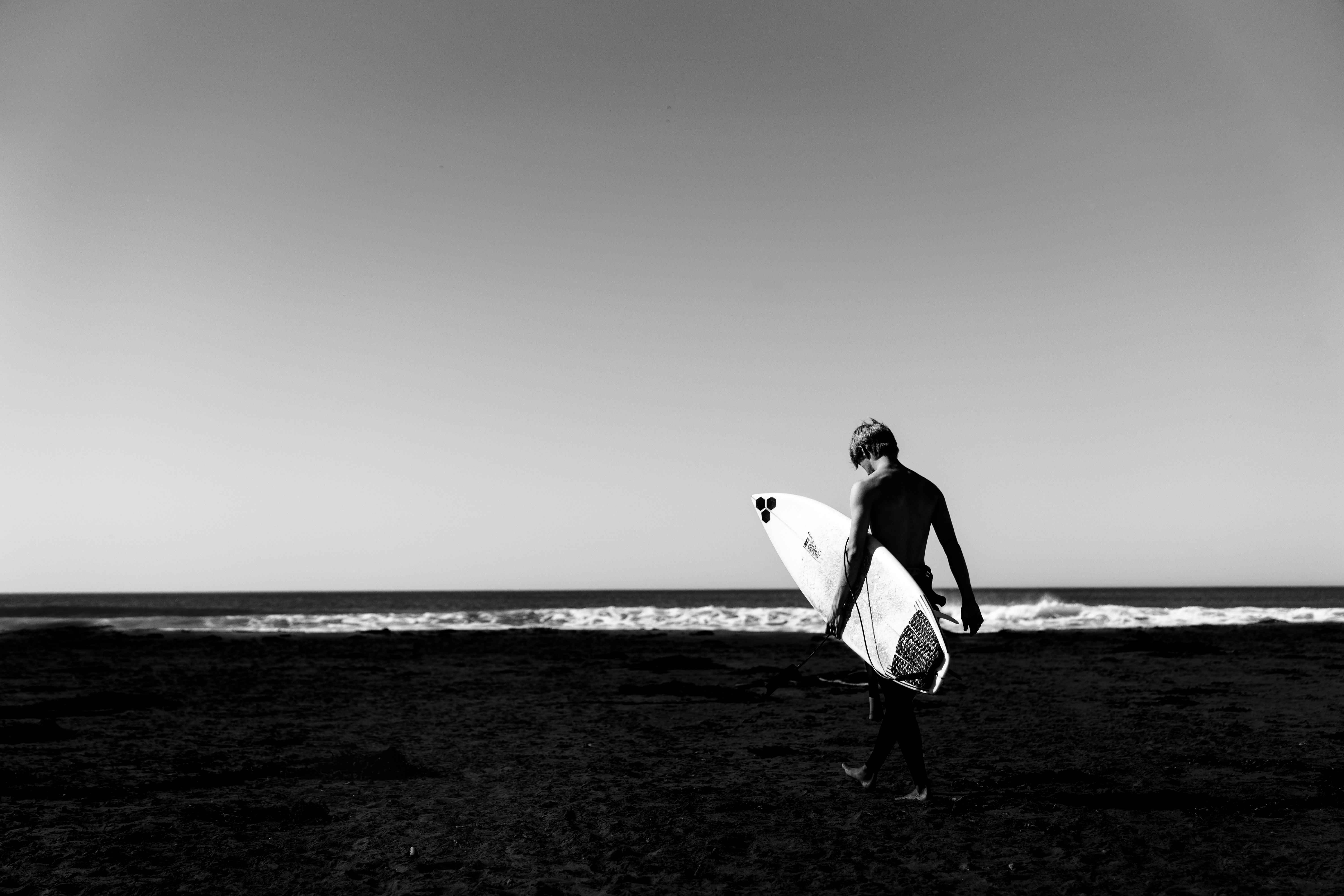 Surfer Walking on Beach with Surfboard
