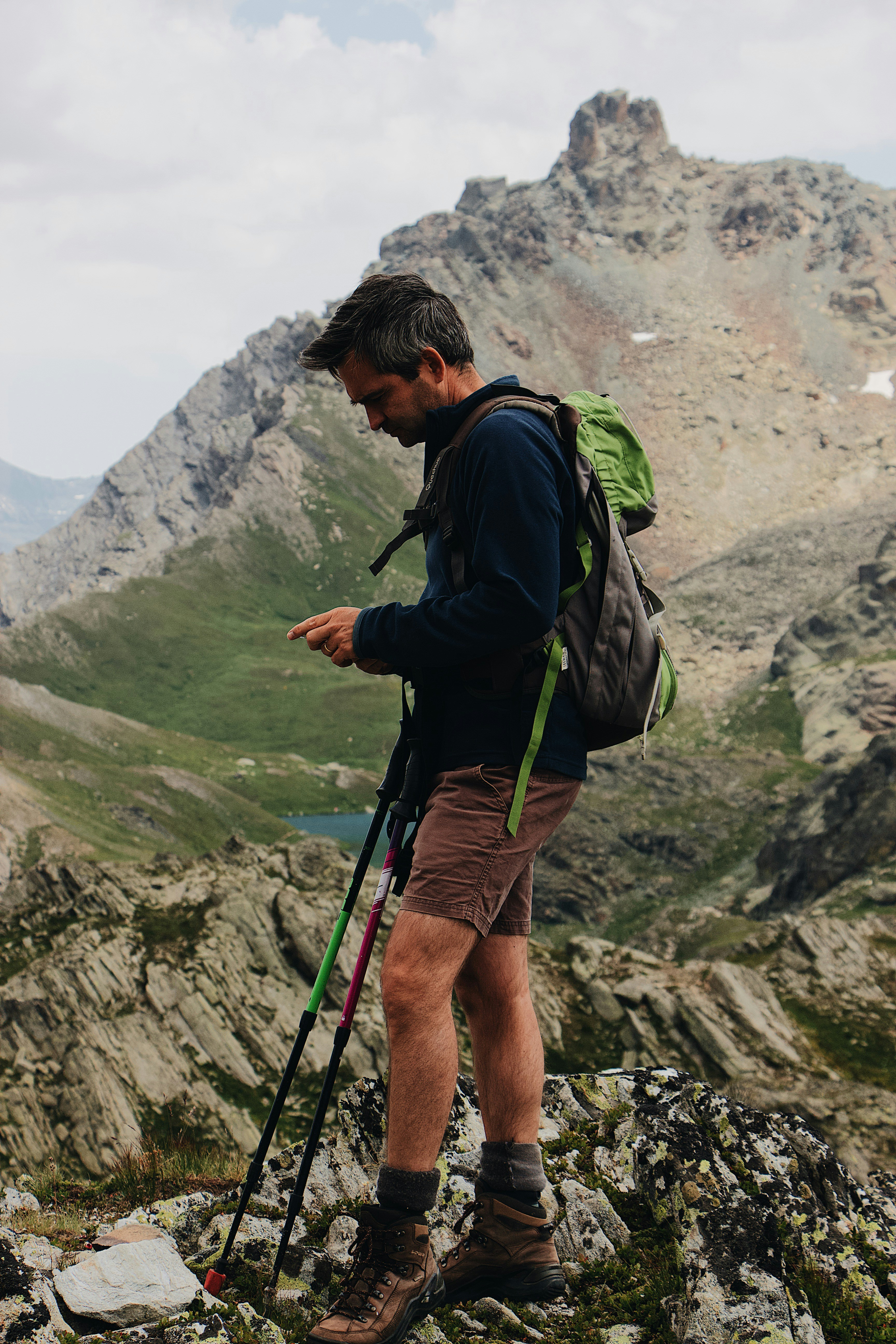 Hiker Checking Phone on Mountain Peak