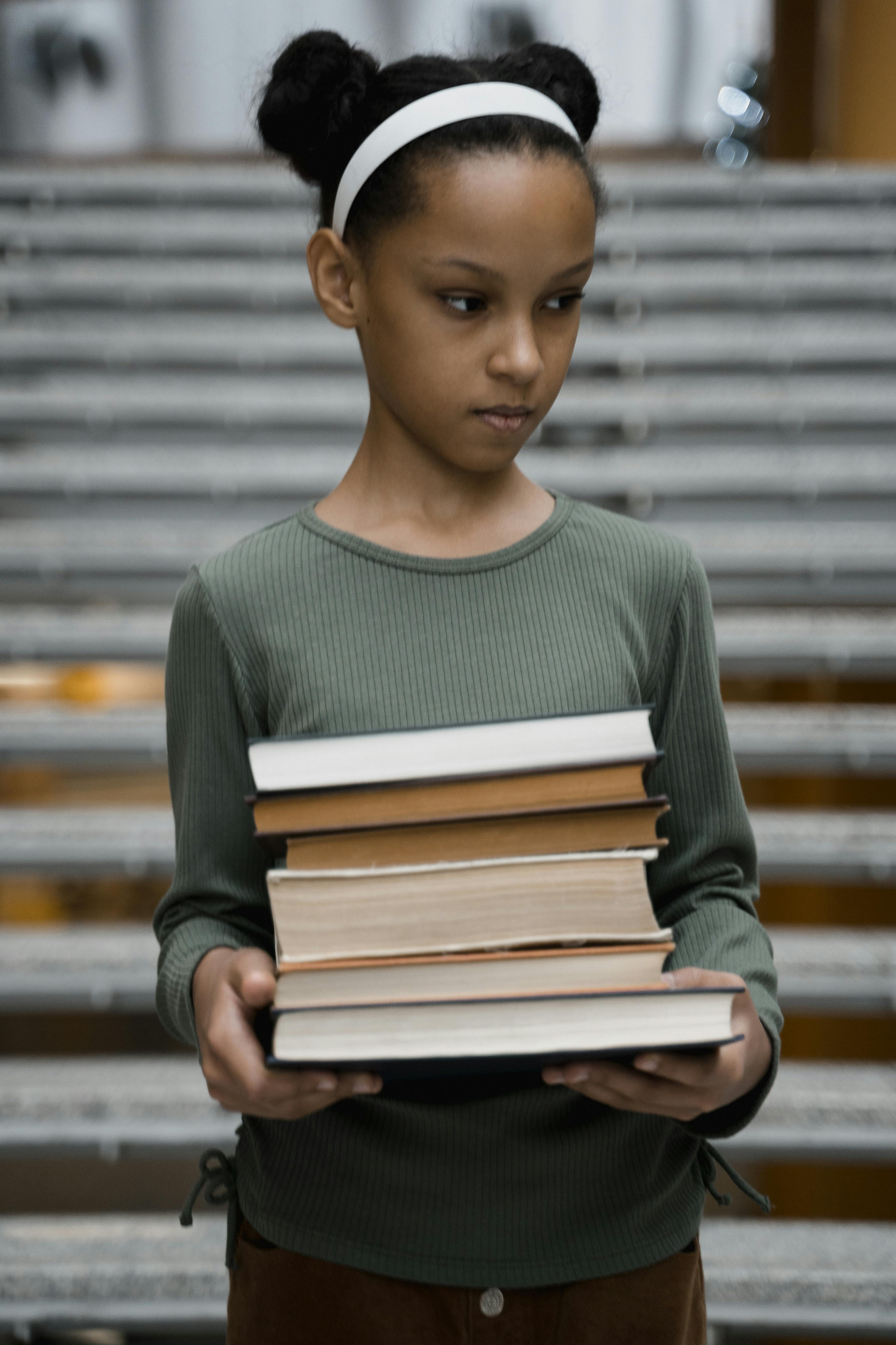 Young Girl Holding Stack of Books