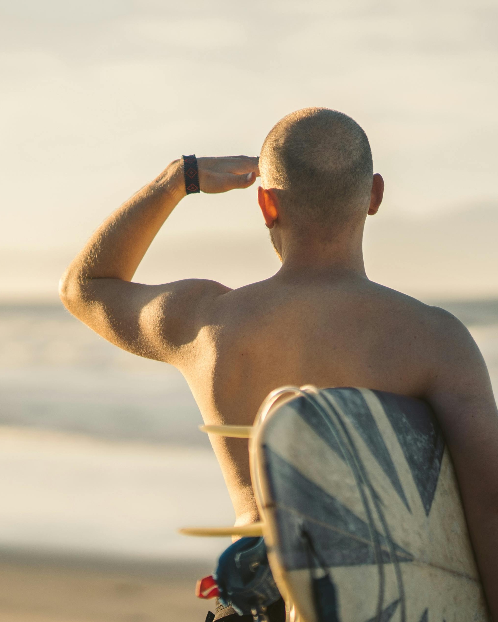 Shirtless Surfer Gazing Out To Sea