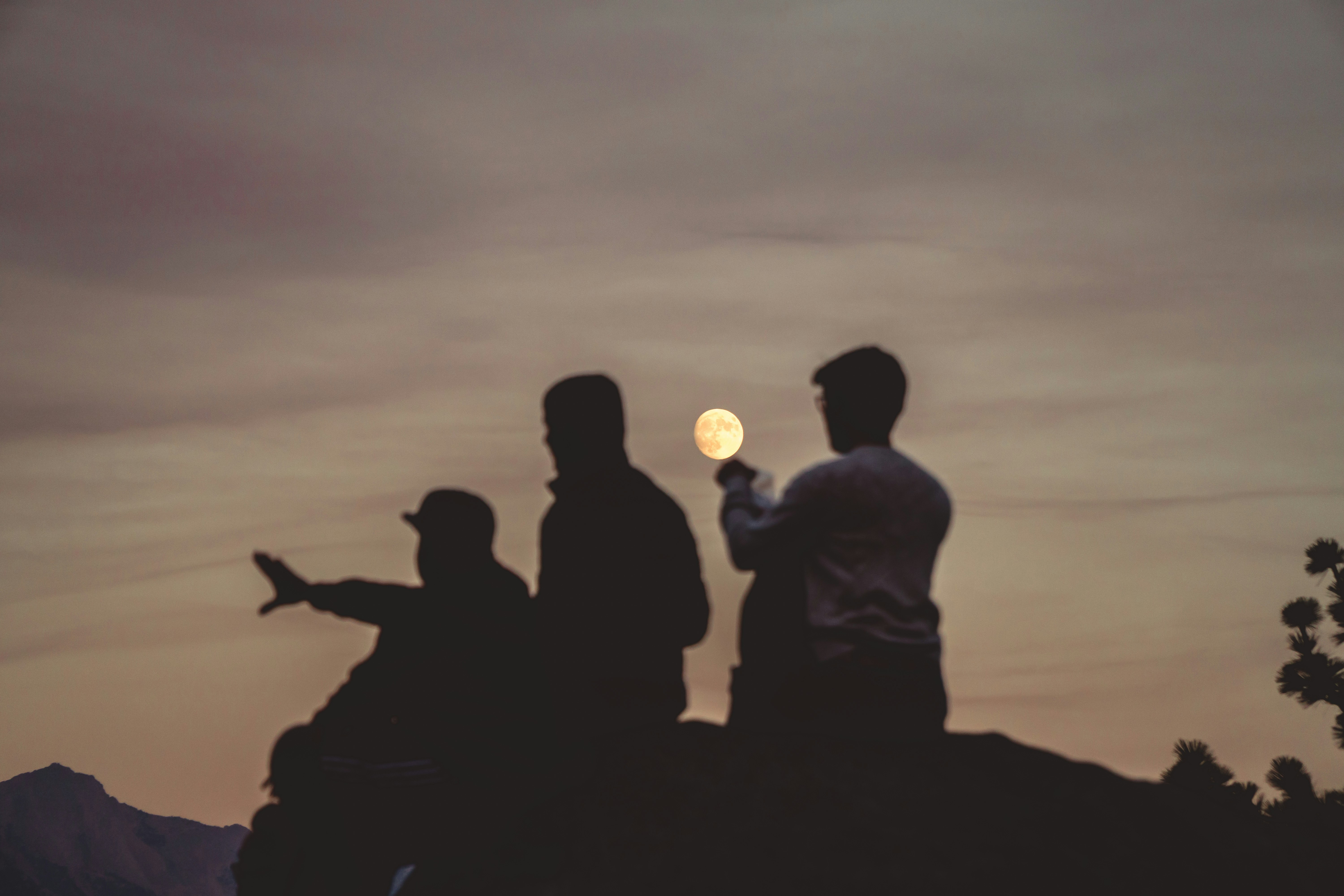 Three People Catching the Full Moon